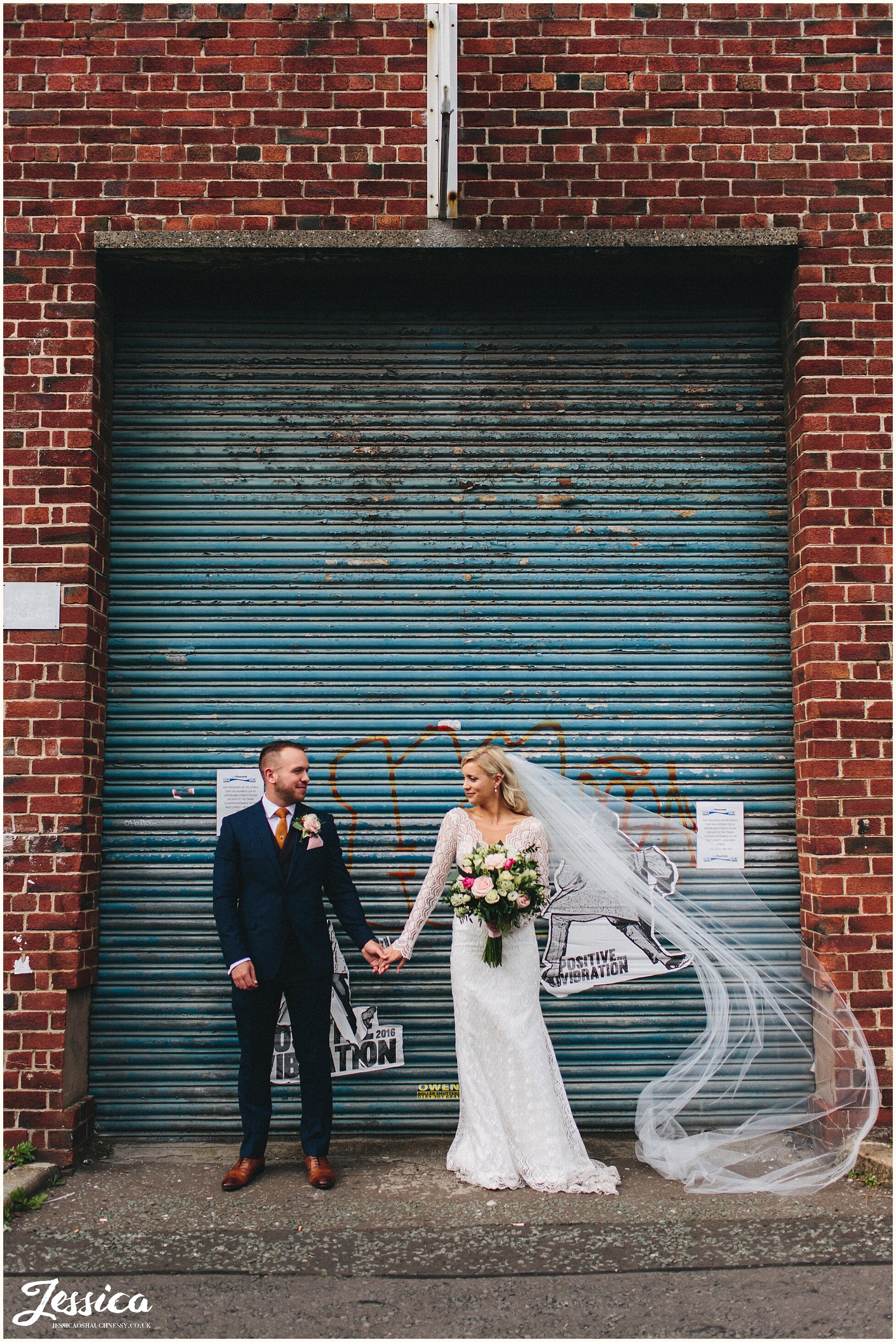 brides veil blows in the wind during urban liverpool photo shoot