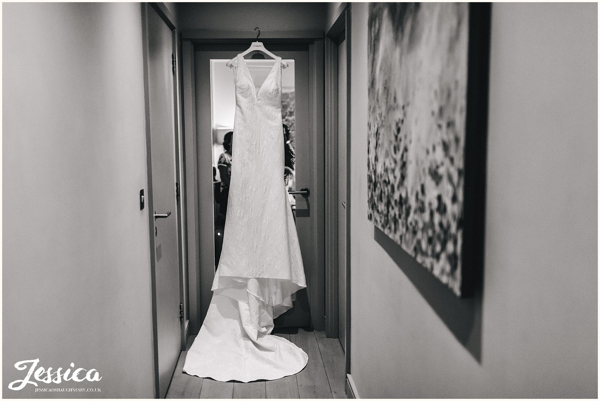 the brides wedding dress hangs ready for the ceremony at the midland hotel