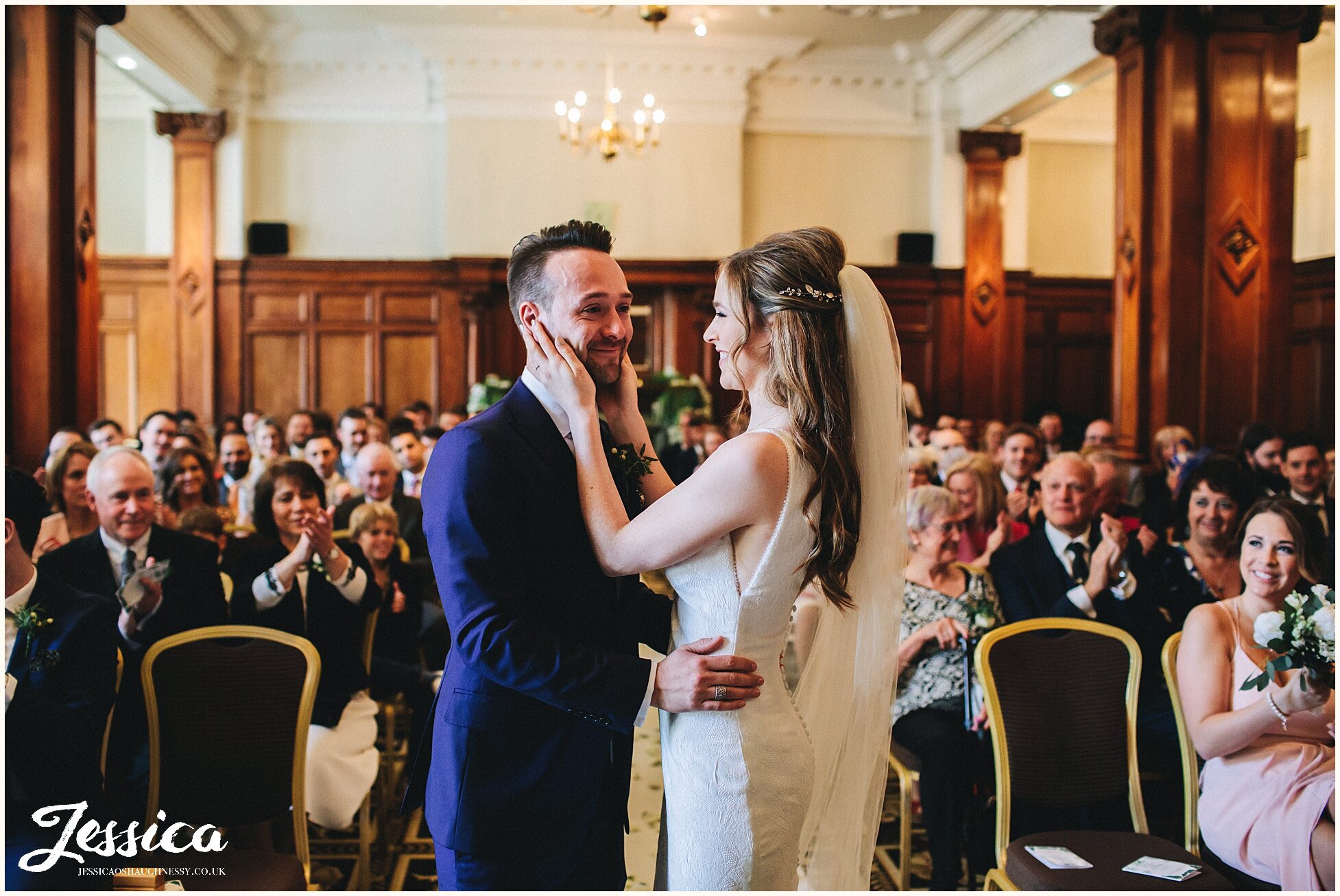 bride lovingly touches her grooms face 