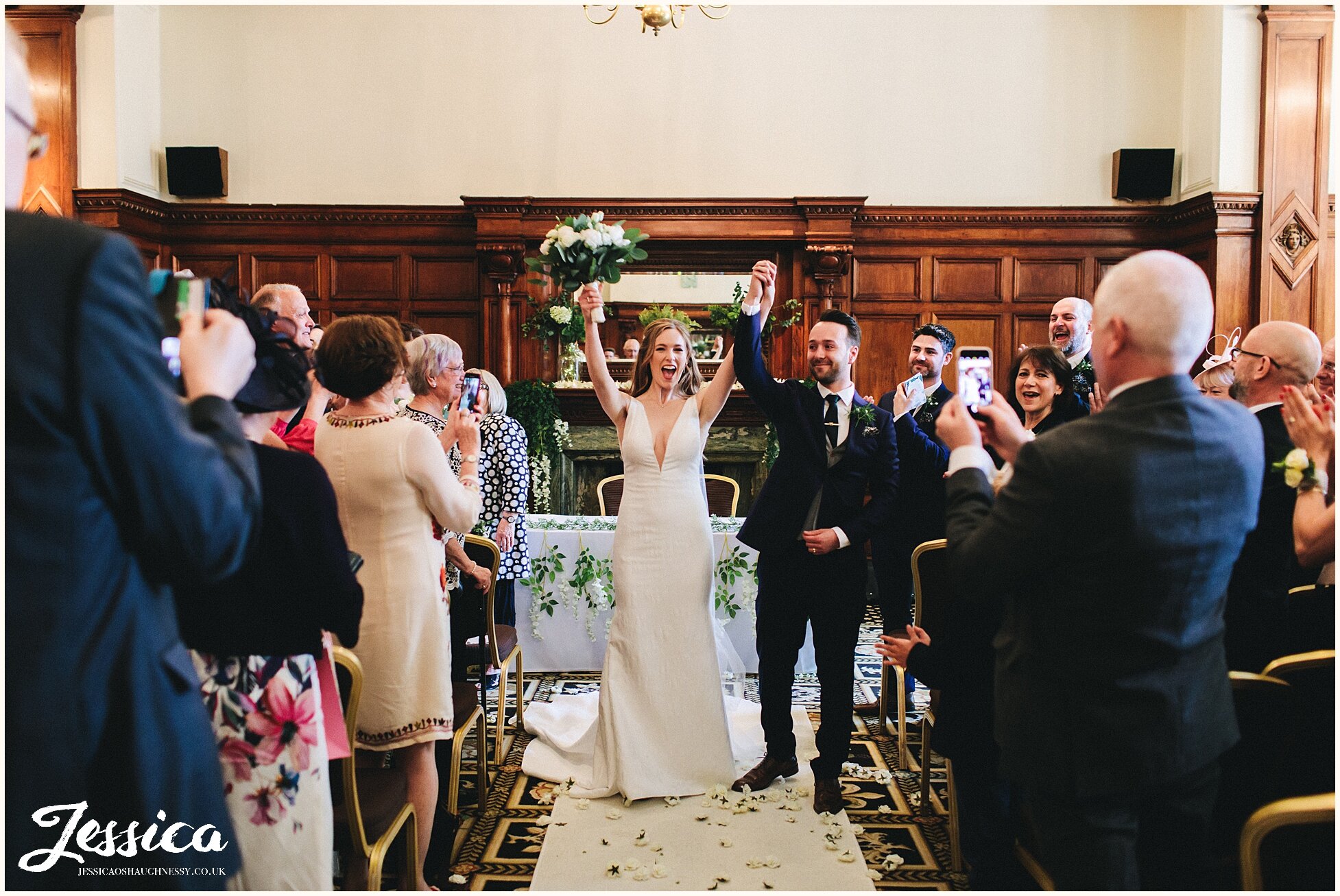 newly wed's cheer as they walk down the aisle as man &amp; wife