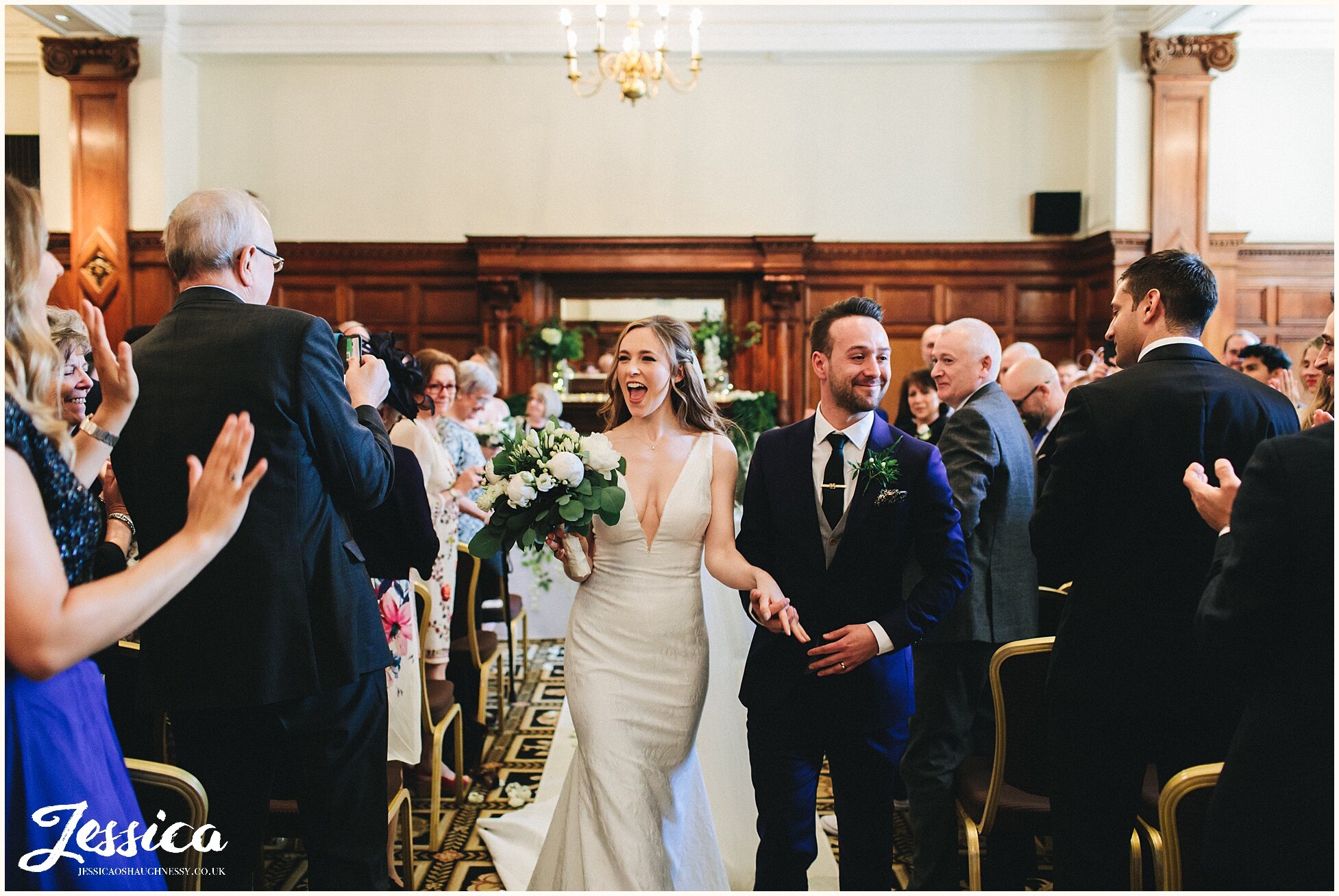 bride &amp; groom dance down the aisle at the midland hotel