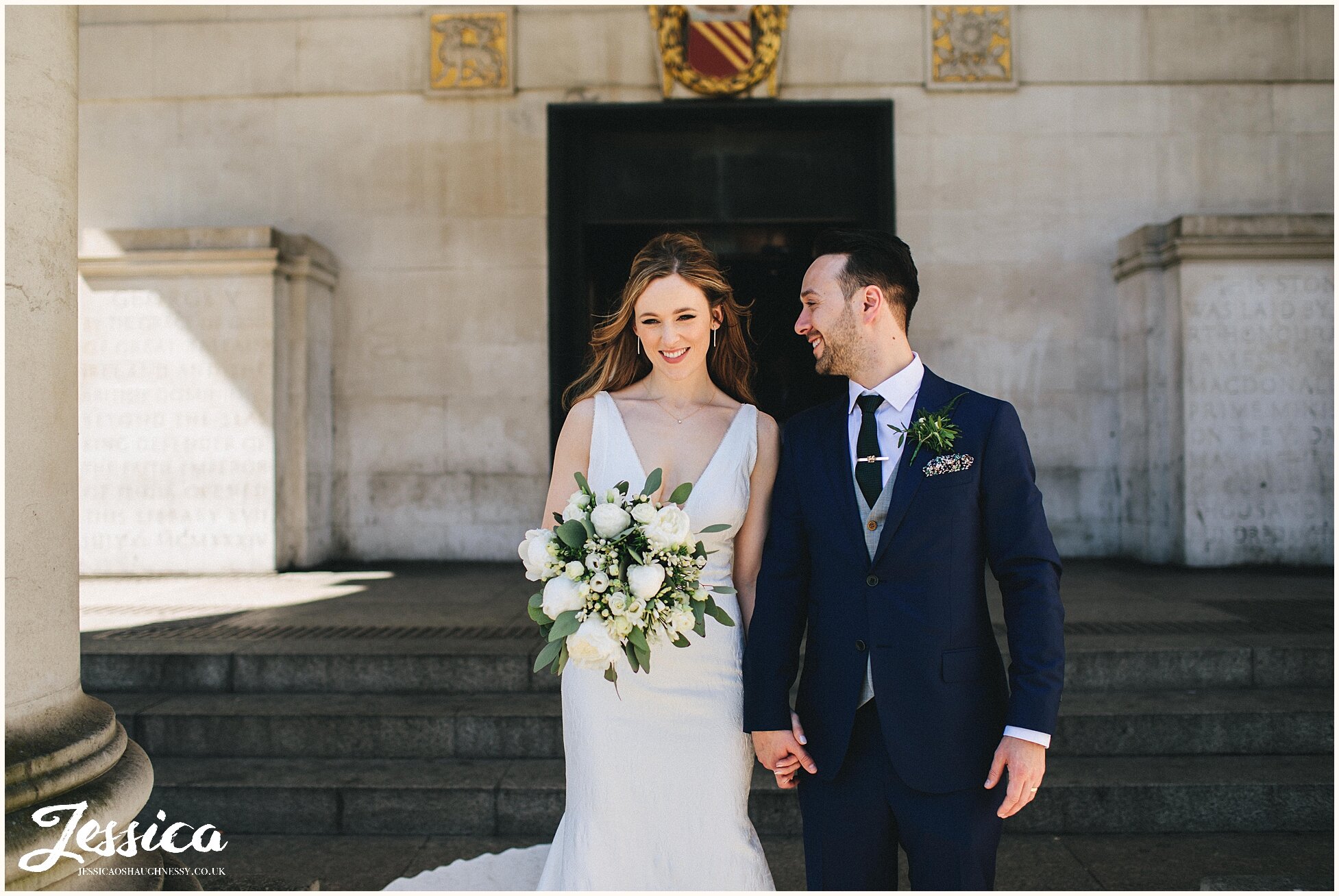 groom looks lovingly at his bride outside manchester library