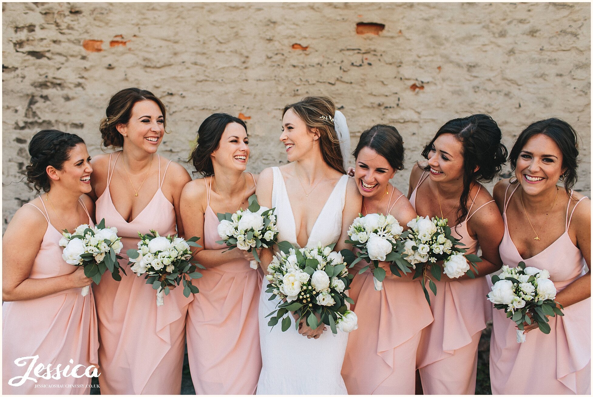 bride &amp; her bridesmaids laughing together