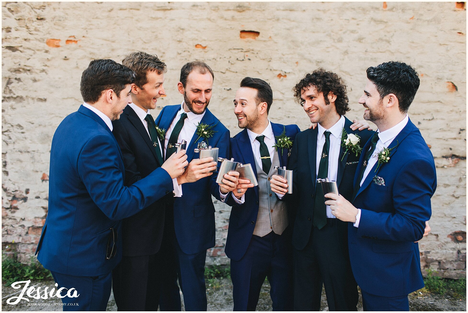 groom drinks out of hip flask with his groomsmen