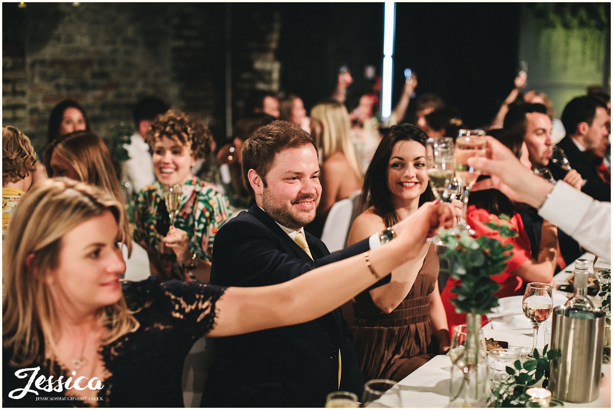 wedding guests cheers during the speeches