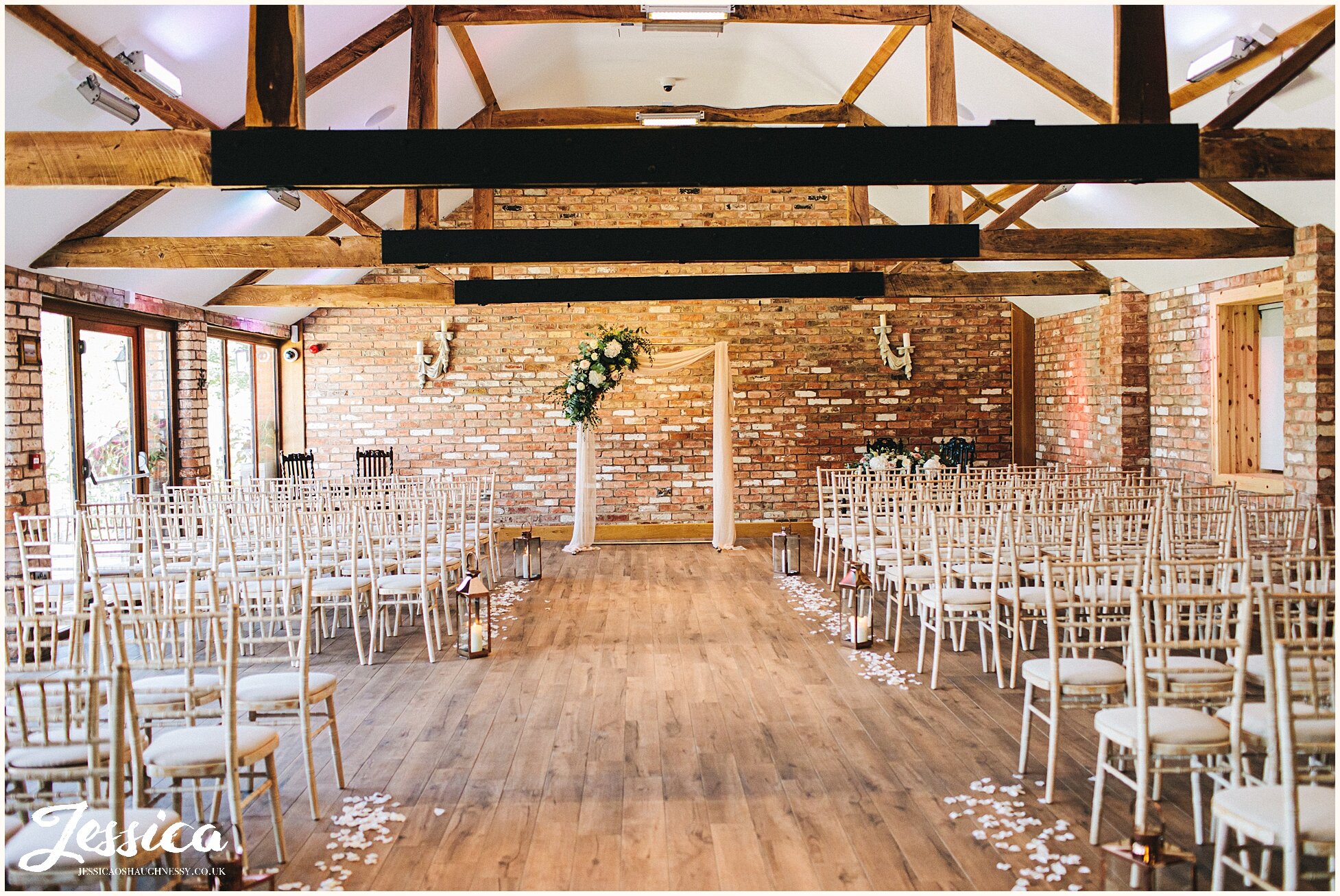 a floral arch decorates the oak barn for the ceremony