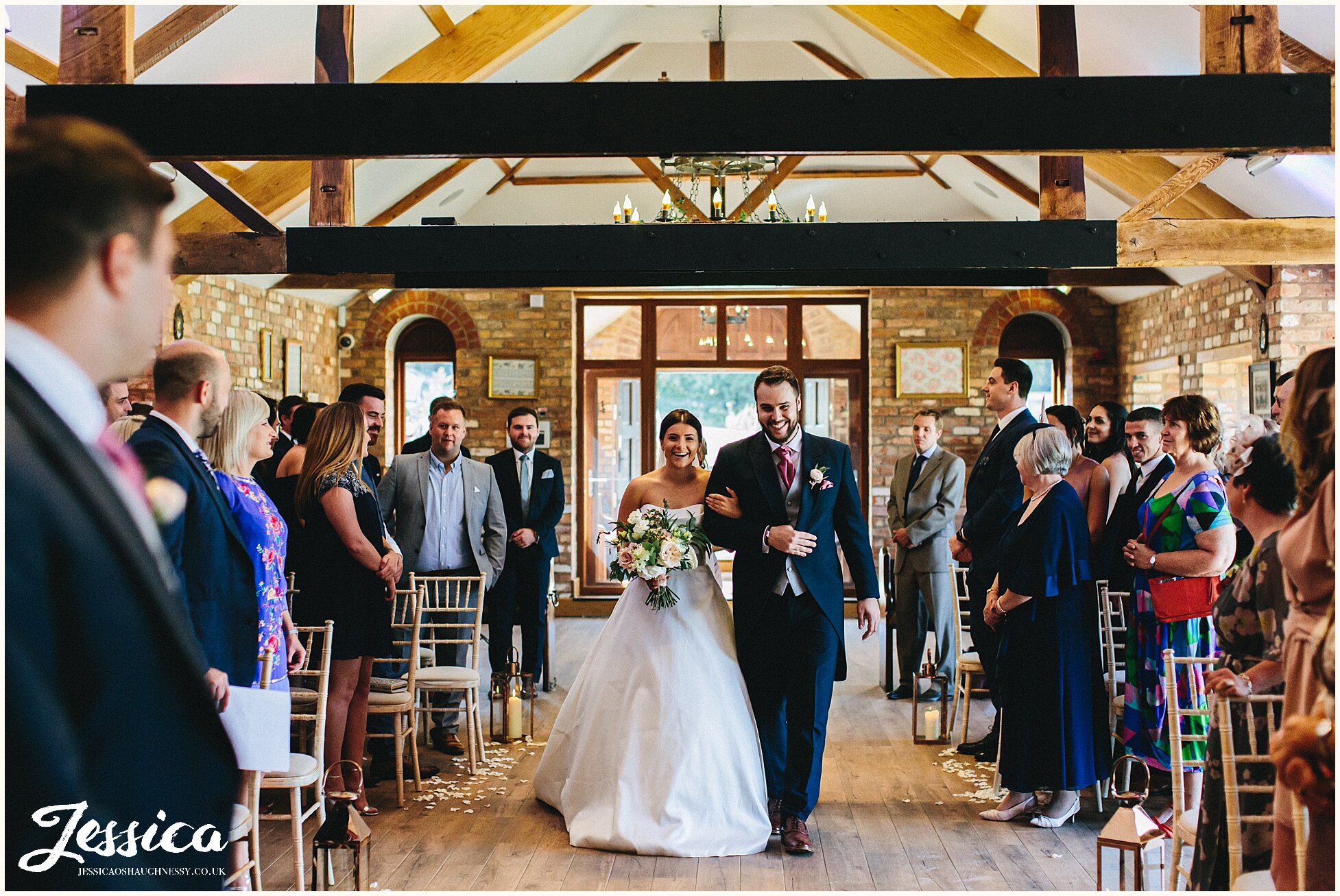 bride walks down the aisle with her brother at keythorpe manor