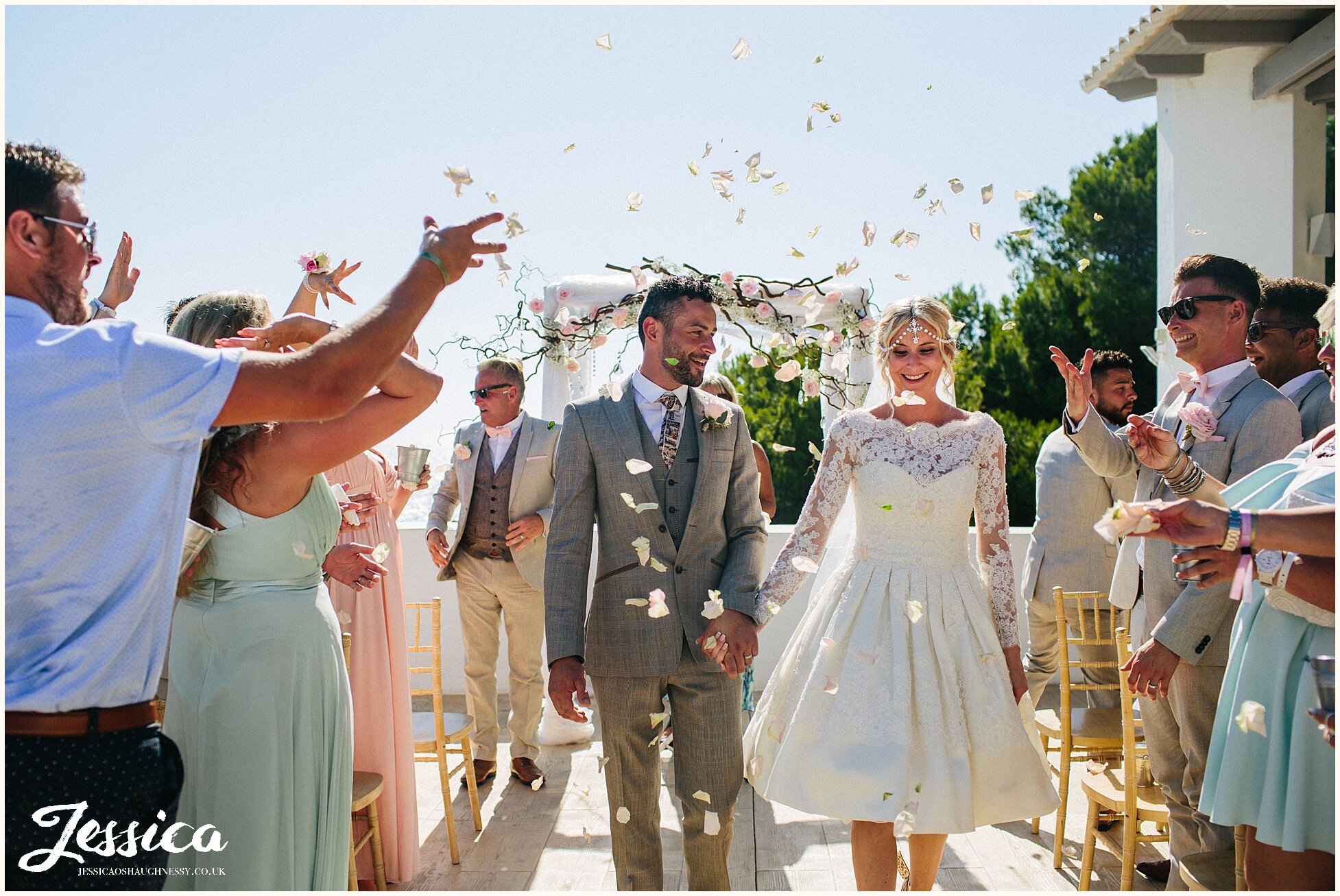 newly wed's exit their ceremony as guests throw confetti - wedding photography at Elixir, Ibiza