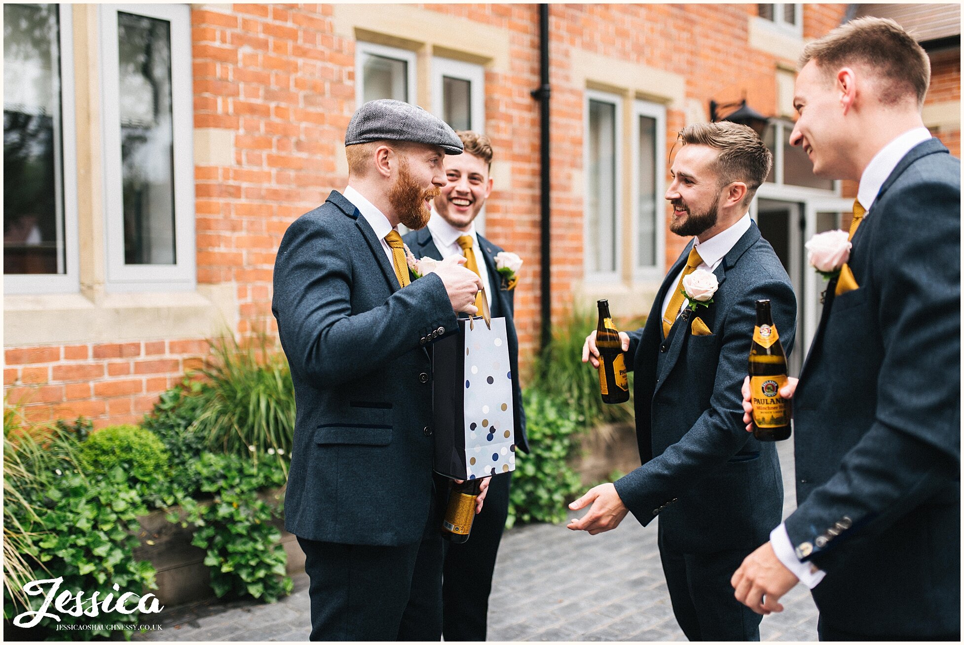groom &amp; groomsmen have a beer in the sun before the ceremony