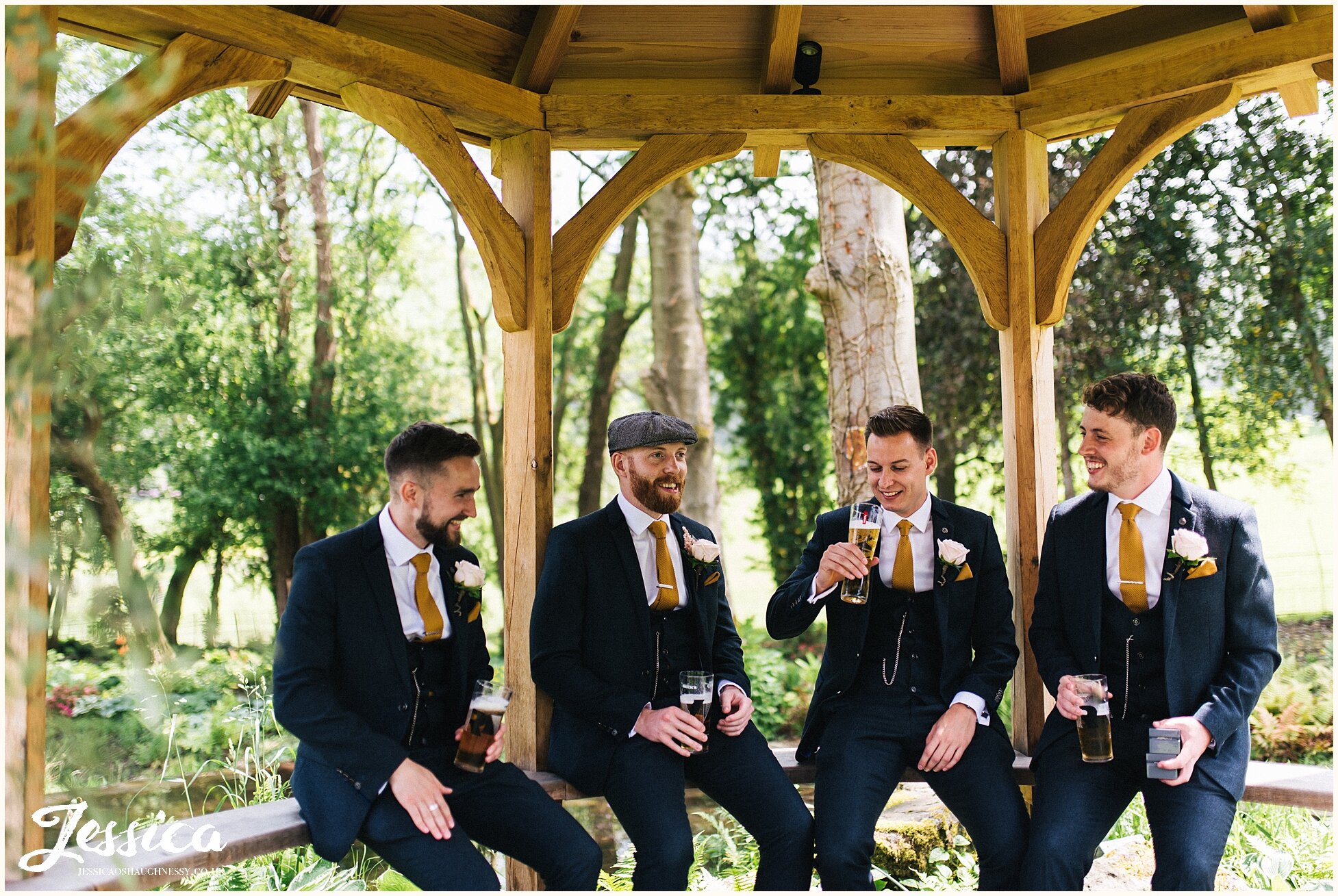 groomsmen sit in tyn dwr hall's grounds waiting for the ceremony