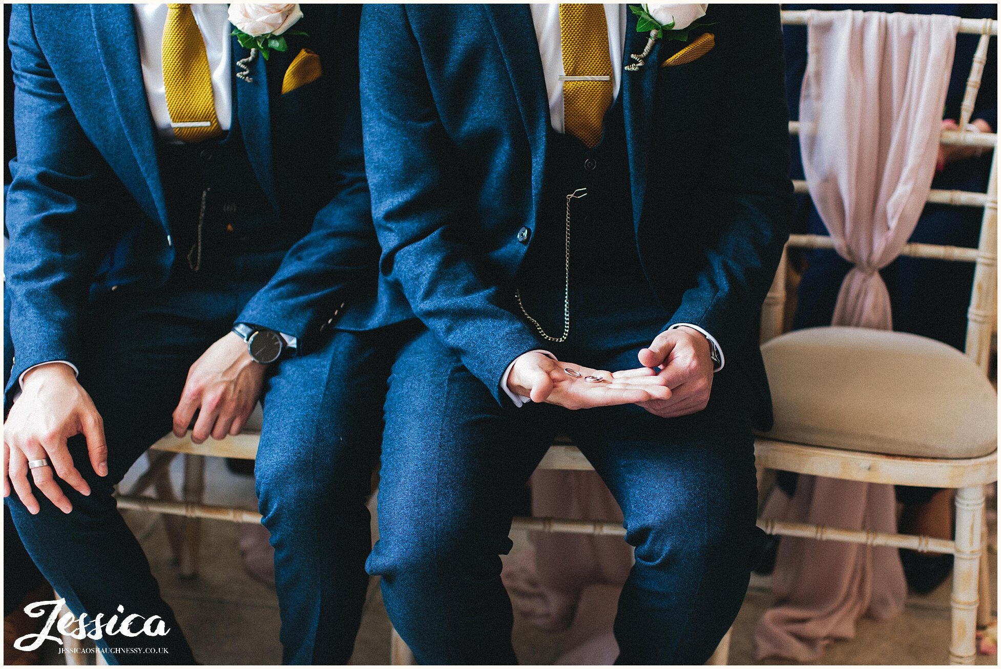 groomsmen holds the wedding rings carefully