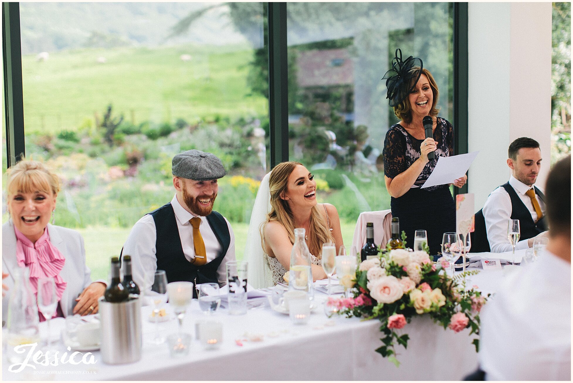mother of the bride delivers her speech as the bride laughs