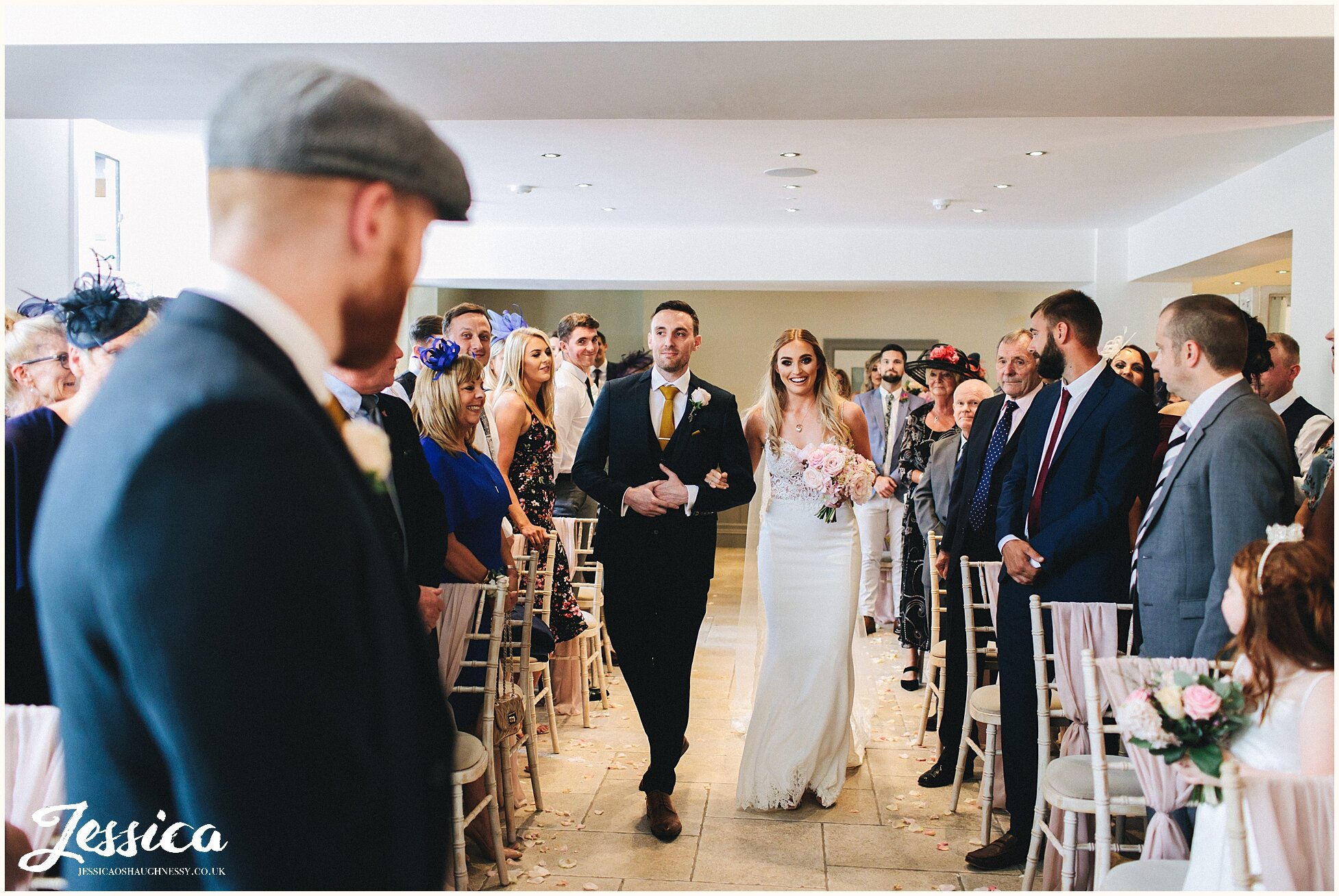 the bride walks down the aisle with her brother, seeing the groom for the first time