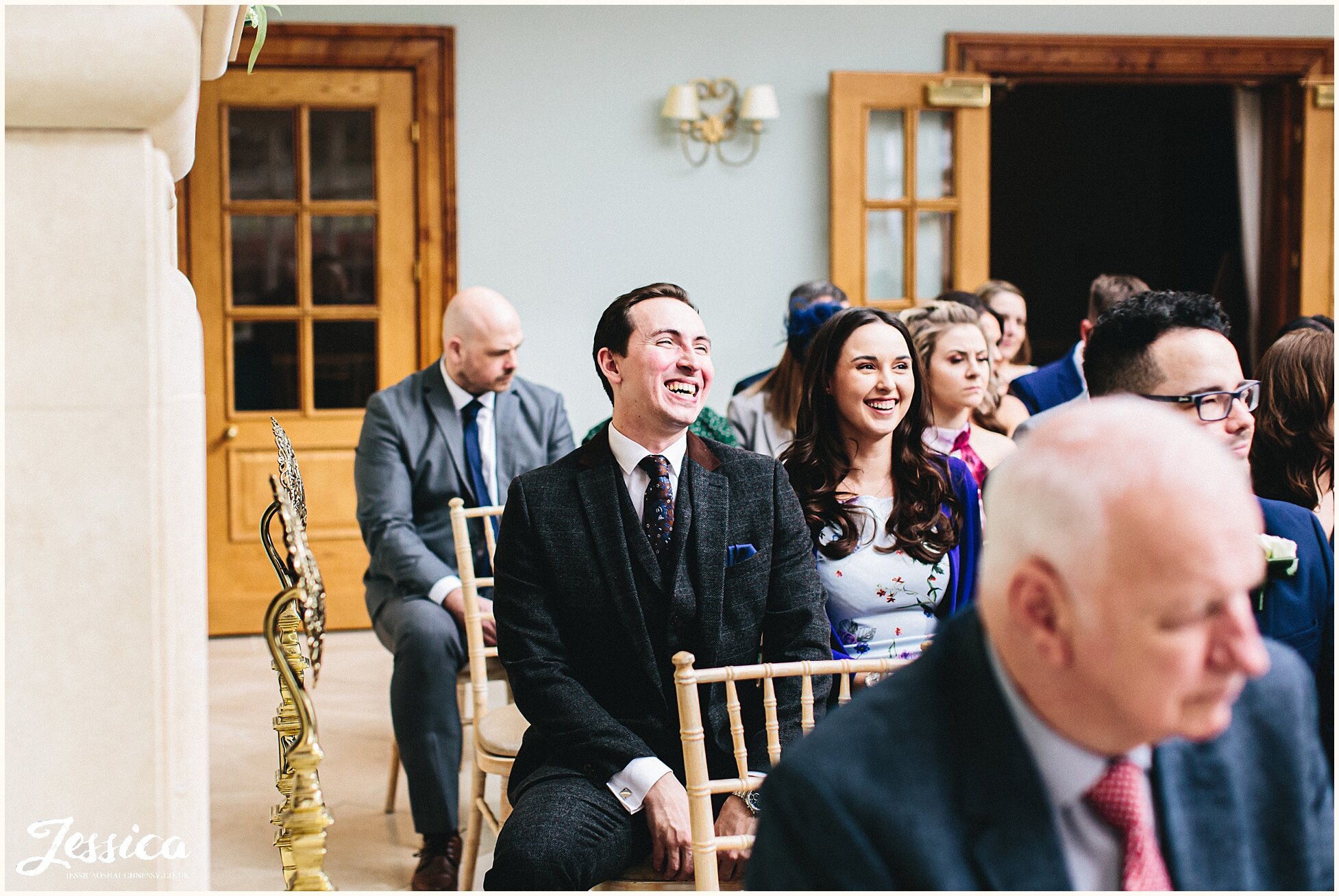 guests laugh as they are seated for the Willington Hall wedding ceremony