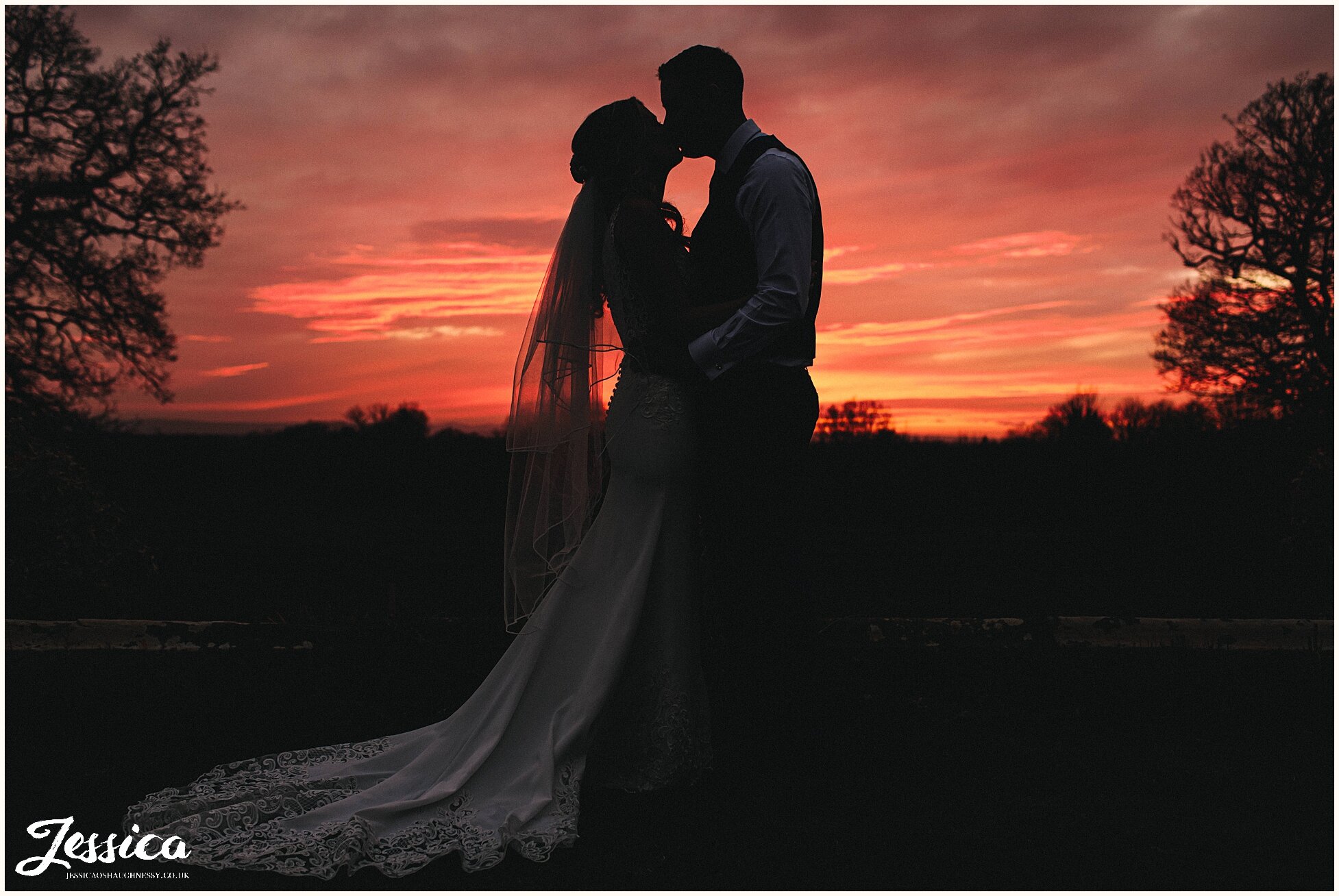 couple stand in front sunset at Willington Hall in cheshire