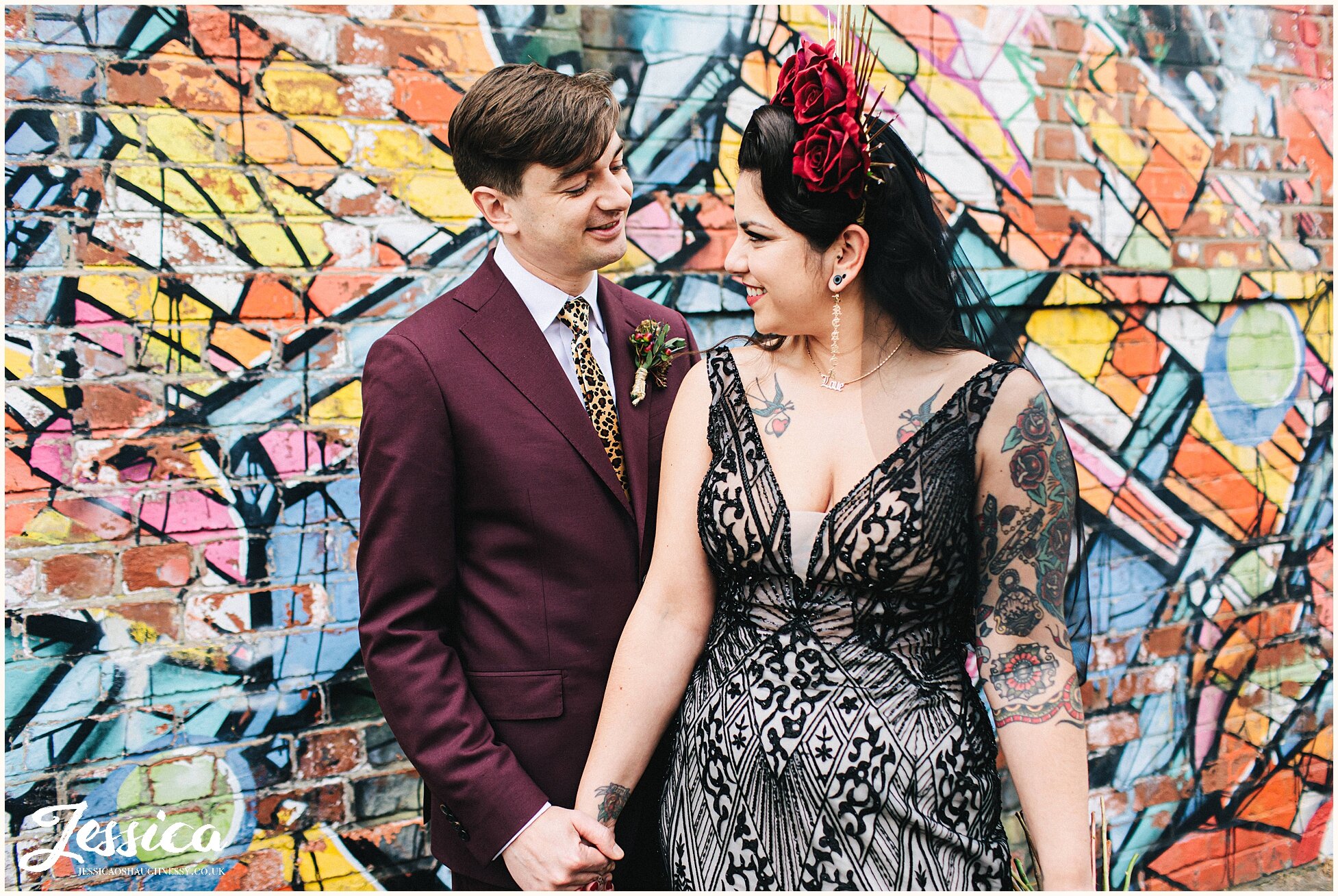 newly wed's stand in front of graffiti in the baltic triangle, liverpool
