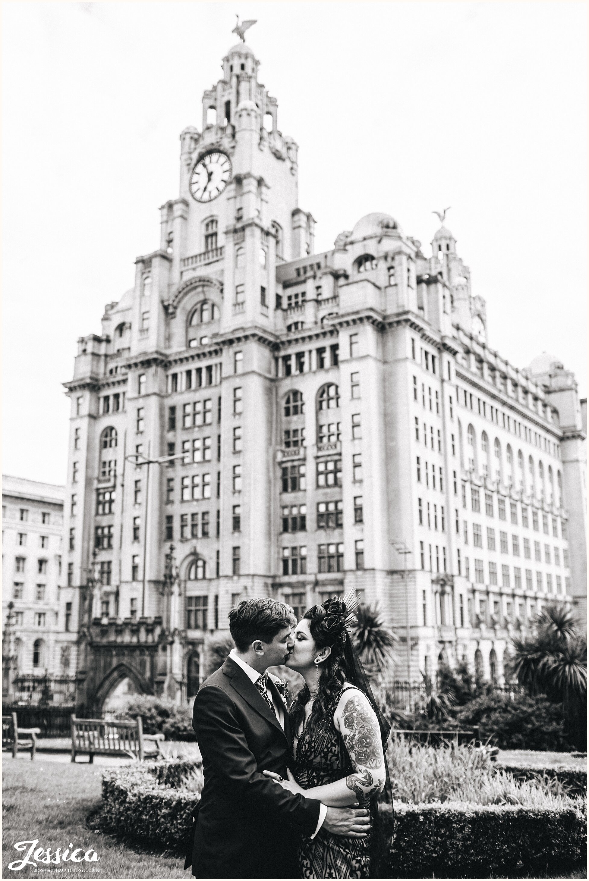 alternative couple kiss in front of liver building in liverpool