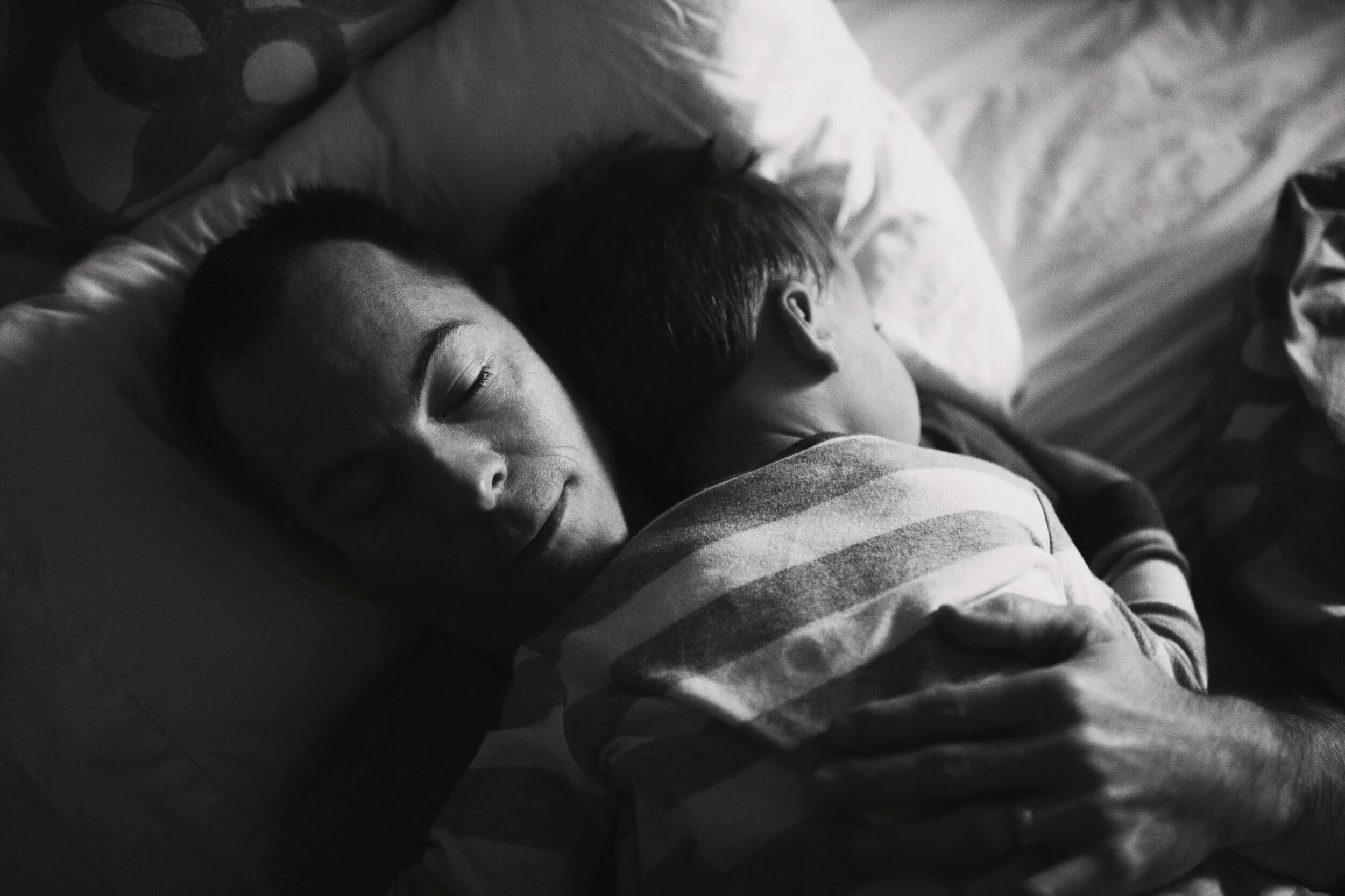 A father snuggles with his son during a documentary family photography session by Shuttersmack Photography in Minneapolis, Minnesota.