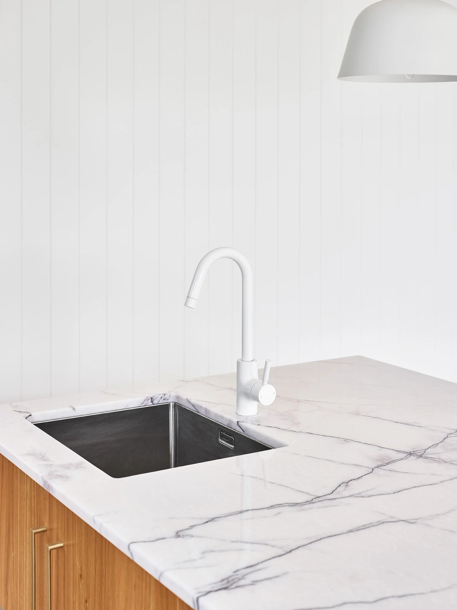   The interior design features New York marble on the island bench top, timber cabinetry and traditional white VJ in Gordon Park, Brisbane.   