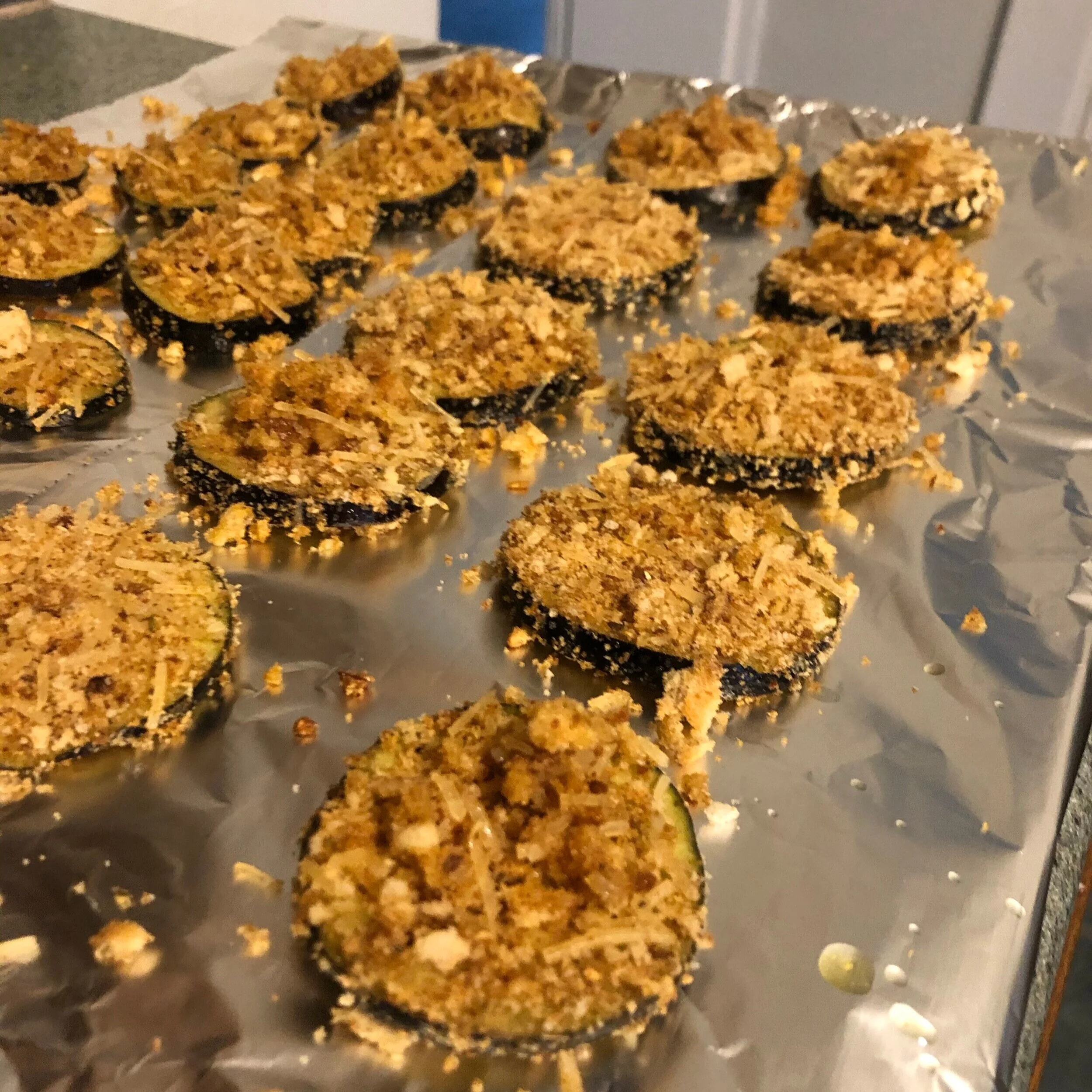  Step 3: Coat eggplant disks first in olive oil, then breadcrumb mixture and place on aluminum foil covered sheet pan.  Bake at 400 degrees F for 15 minutes. Flip disks and cook for another 7 minutes. 