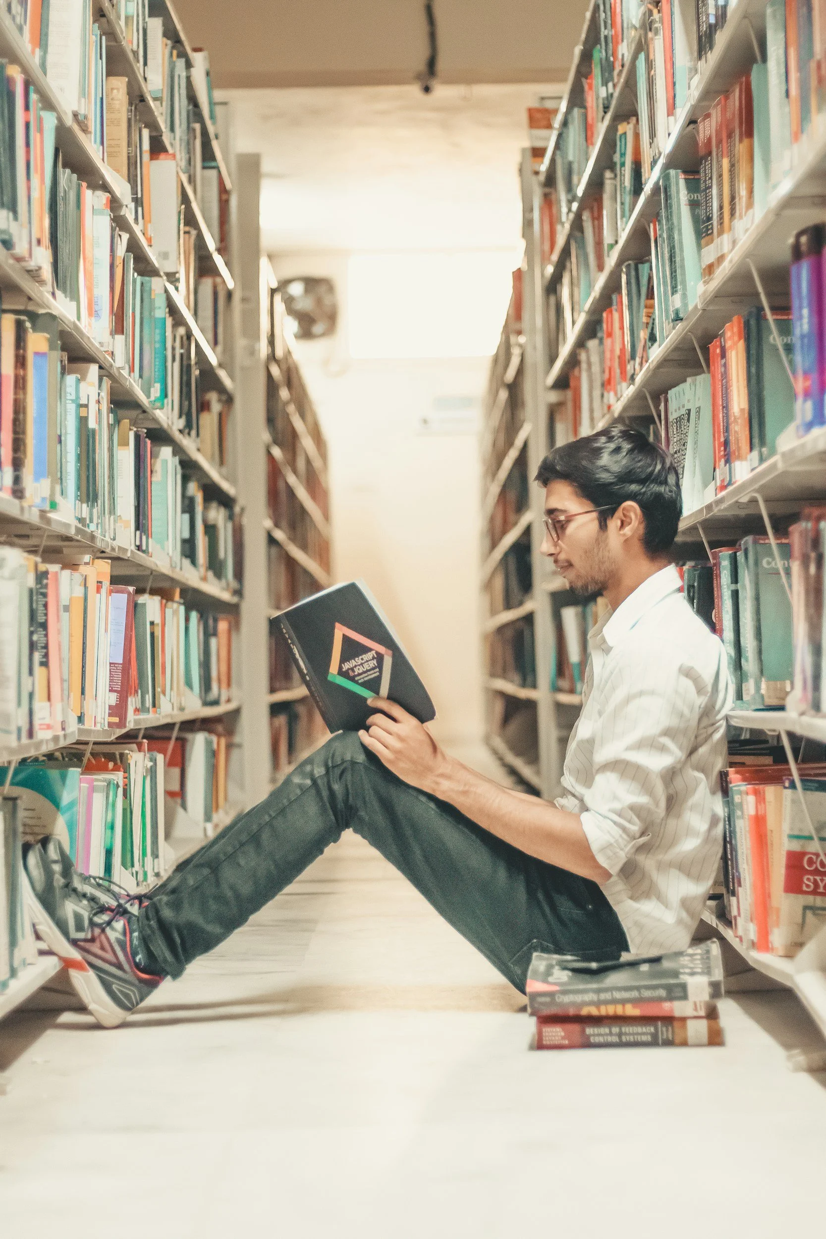 Unsplash image by Kyoshy, student reading in library