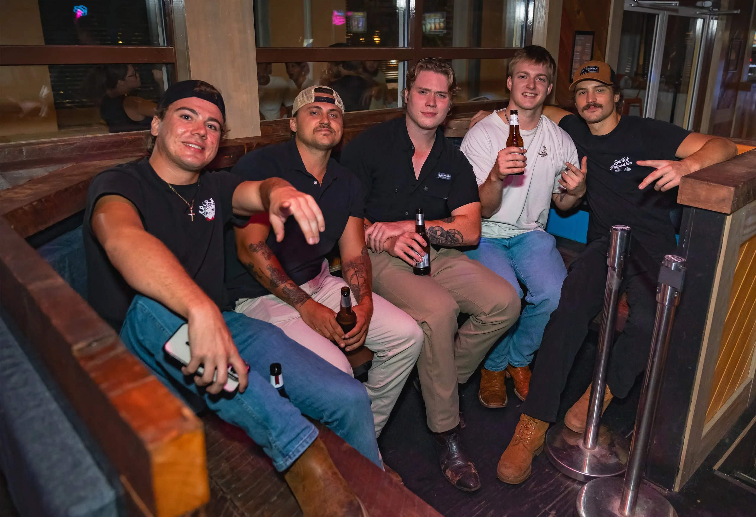 Friends seated together in a booth at High Horse Wilmington.