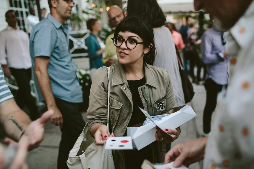 Melody Santiago Cummings hands out unofficial Poetry Society of America bicycle spoke cards.