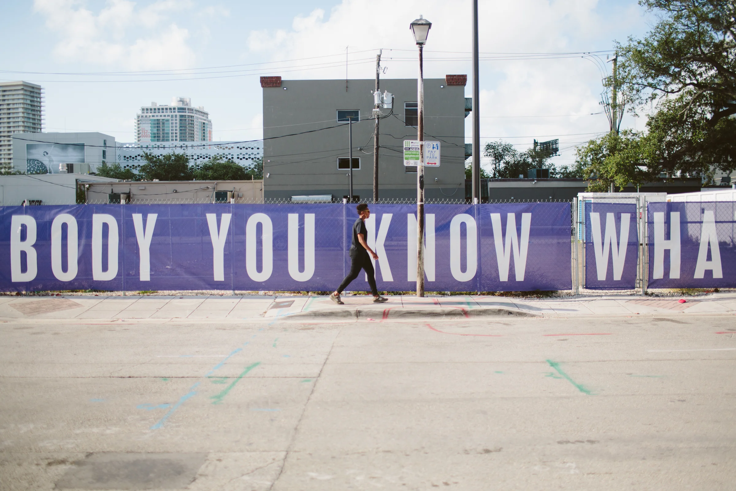 NE 1st Avenue & 41st Street in the Design District , where Martine Syms has installed a purple-and-white banner with the words Sam Cooke spoke to his audience at Harlem Square on one side, and the words of his audience spoke back on the other. 