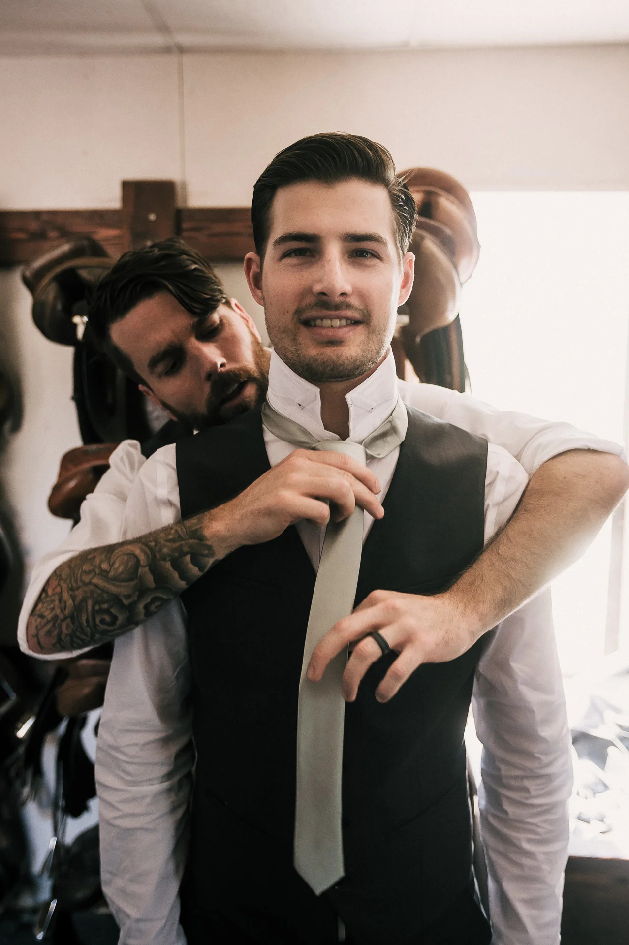 Best man helps groom with tie