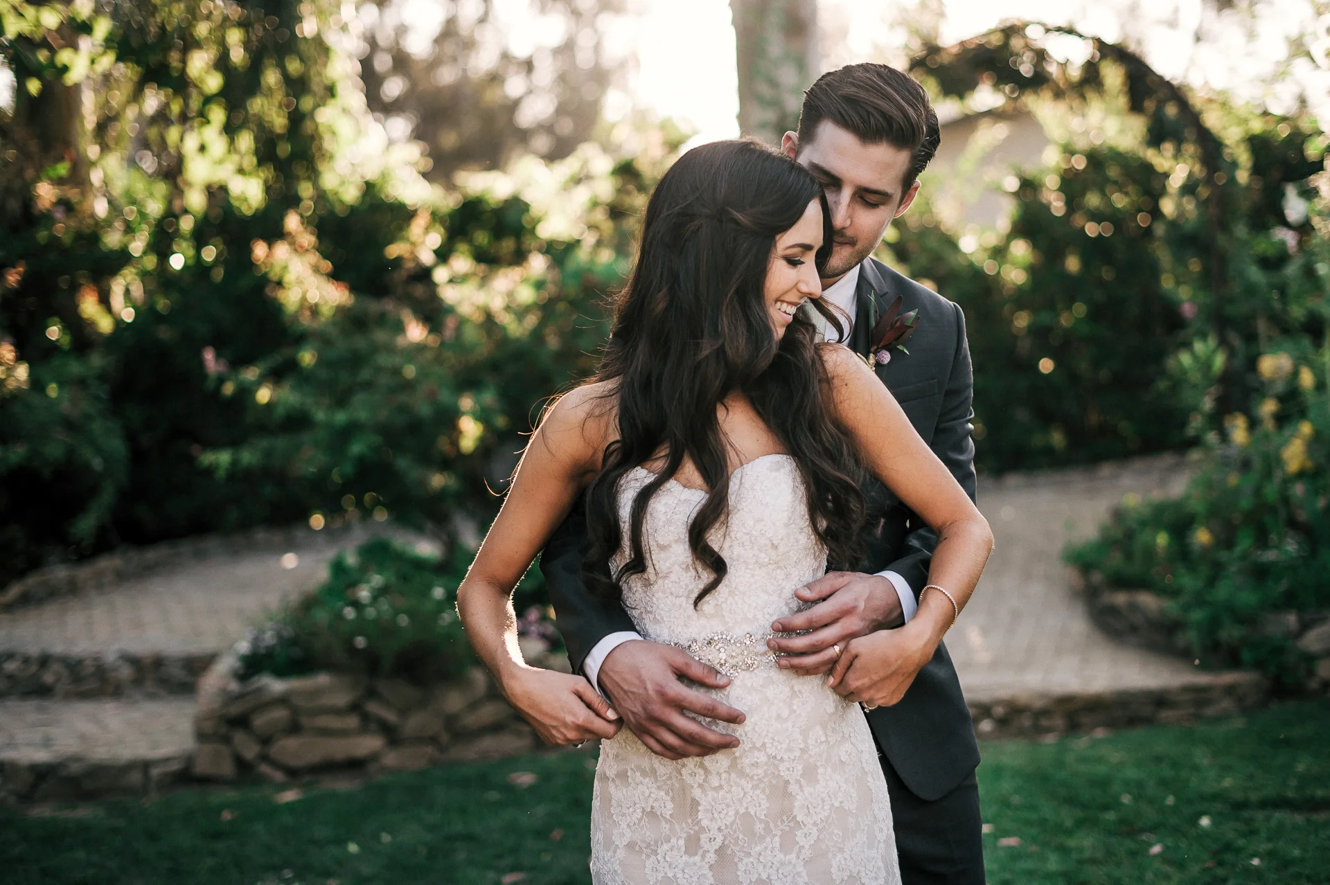 groom wraps his arms around his bride