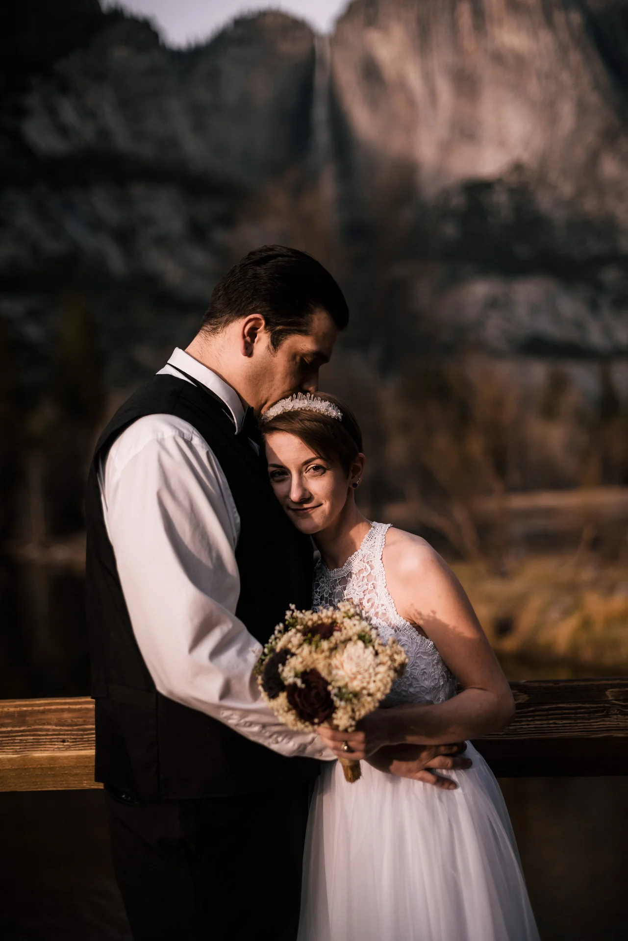 Bride and groom get lost in each others arms after their yosemite elopement at swinging bridge