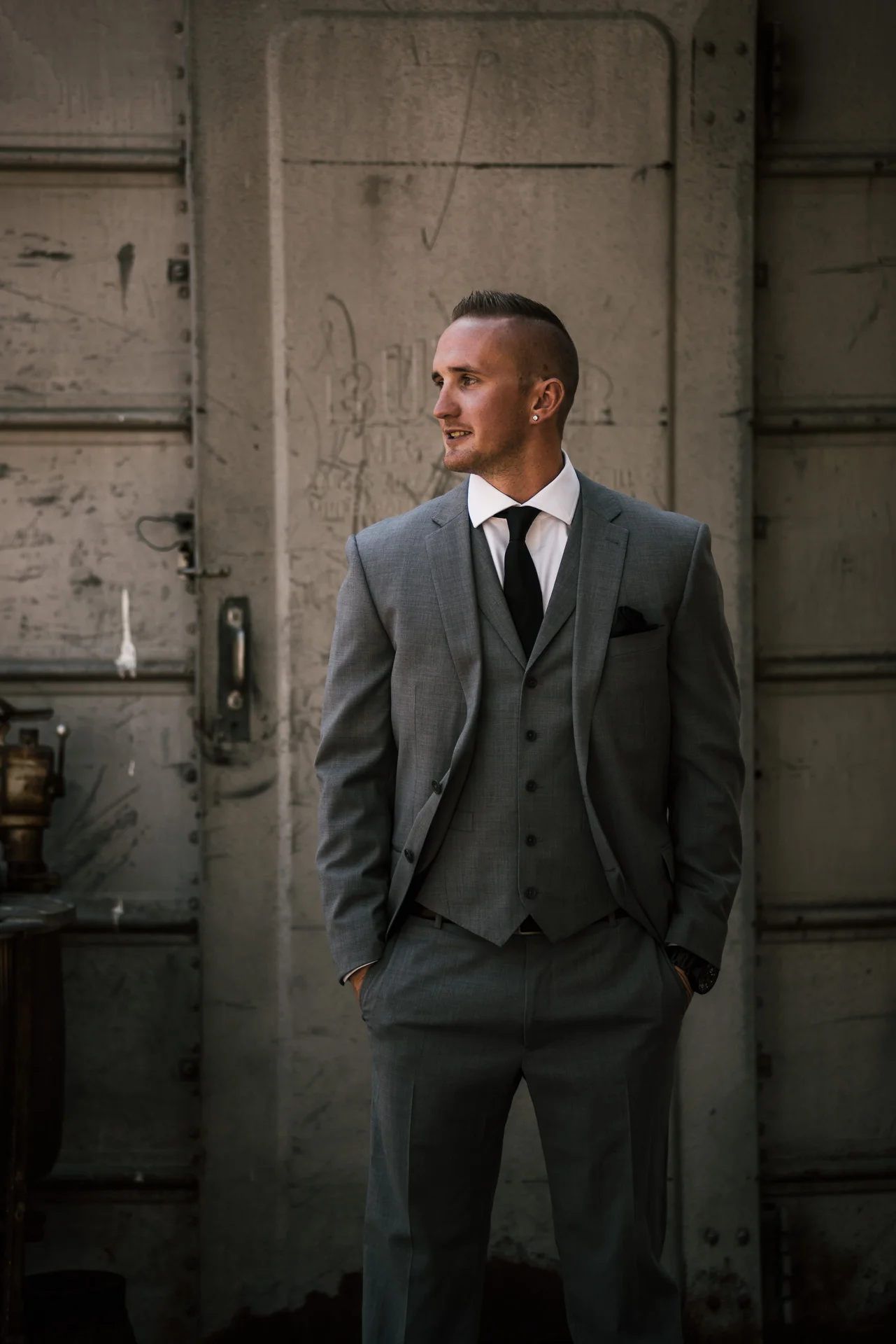 groom in front of old silo waits for bride at rustic pymm ranch wedding venue in winchester california