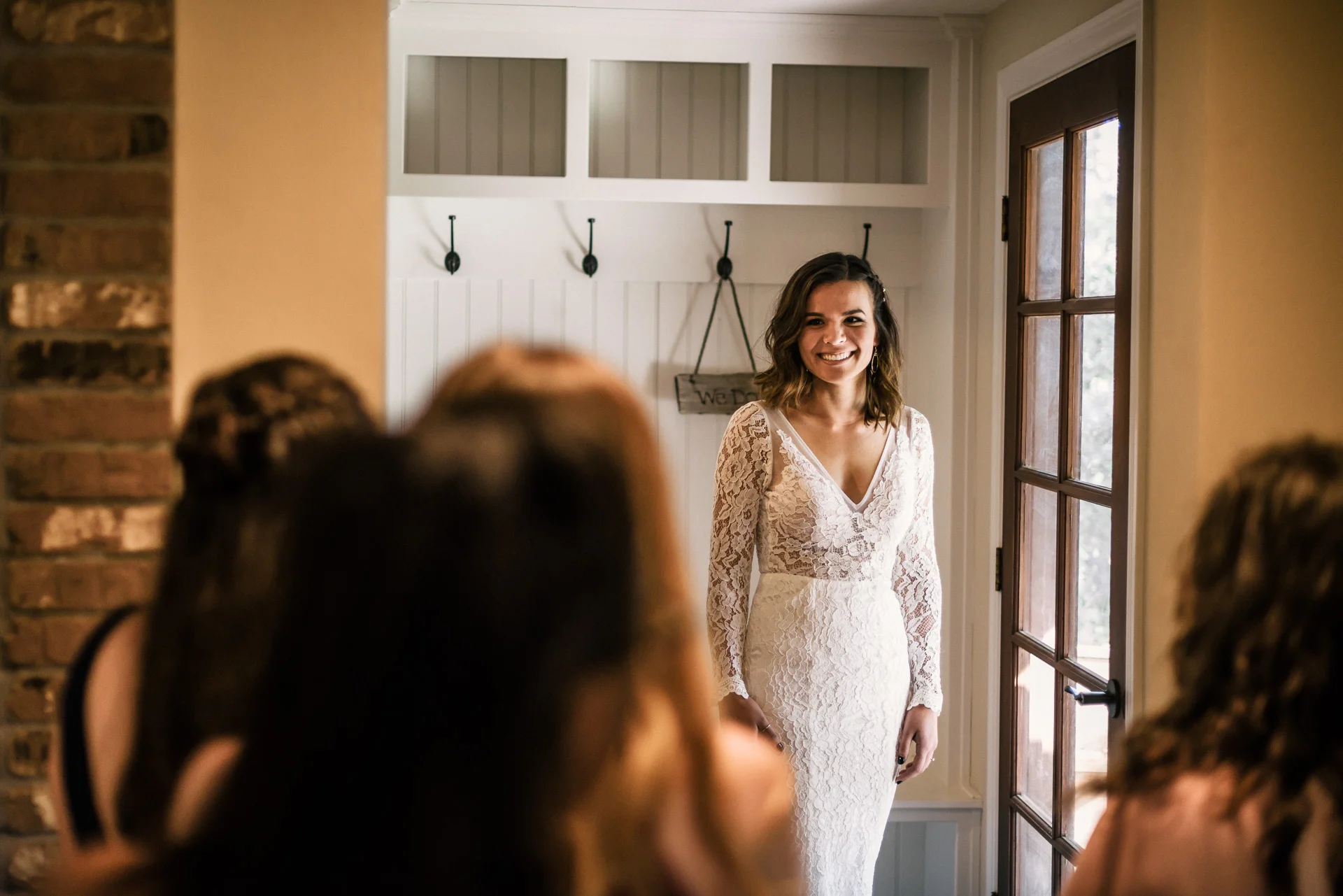 Bride shows off her wedding dress to bridesmaids at rustic pymm ranch wedding venue in winchester california