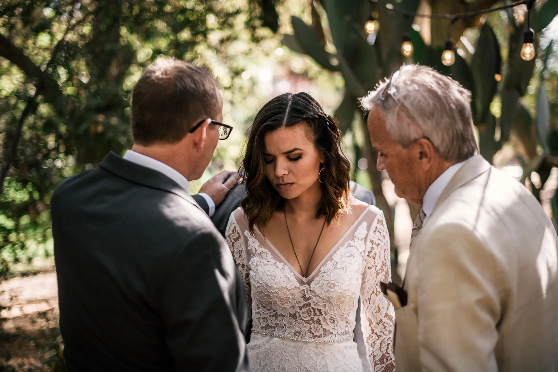 bride and groom's fathers pray for them at rustic pymm ranch wedding venue in winchester california