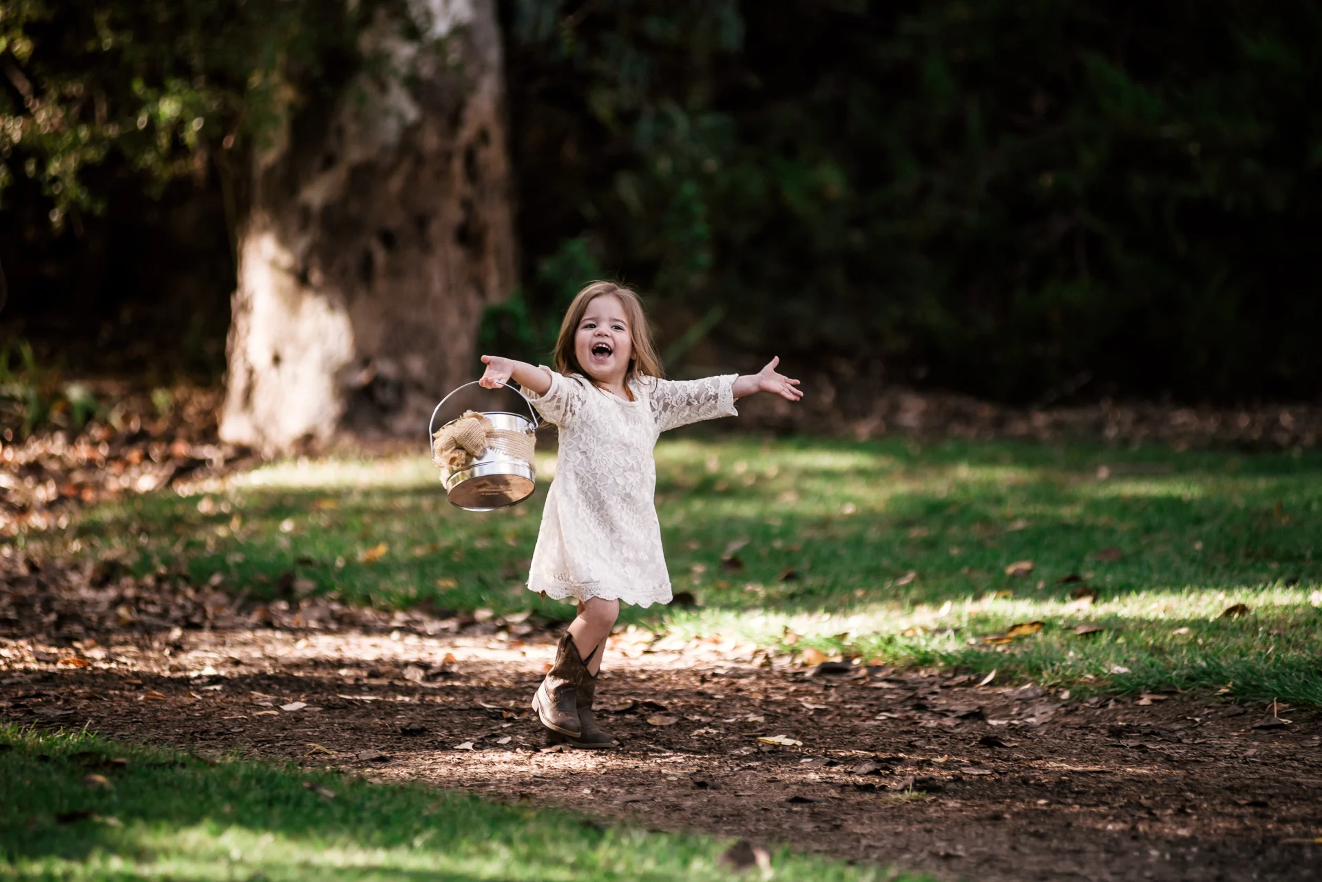 flower girls runs happily down the aisile at rustic pymm ranch wedding venue in winchester california