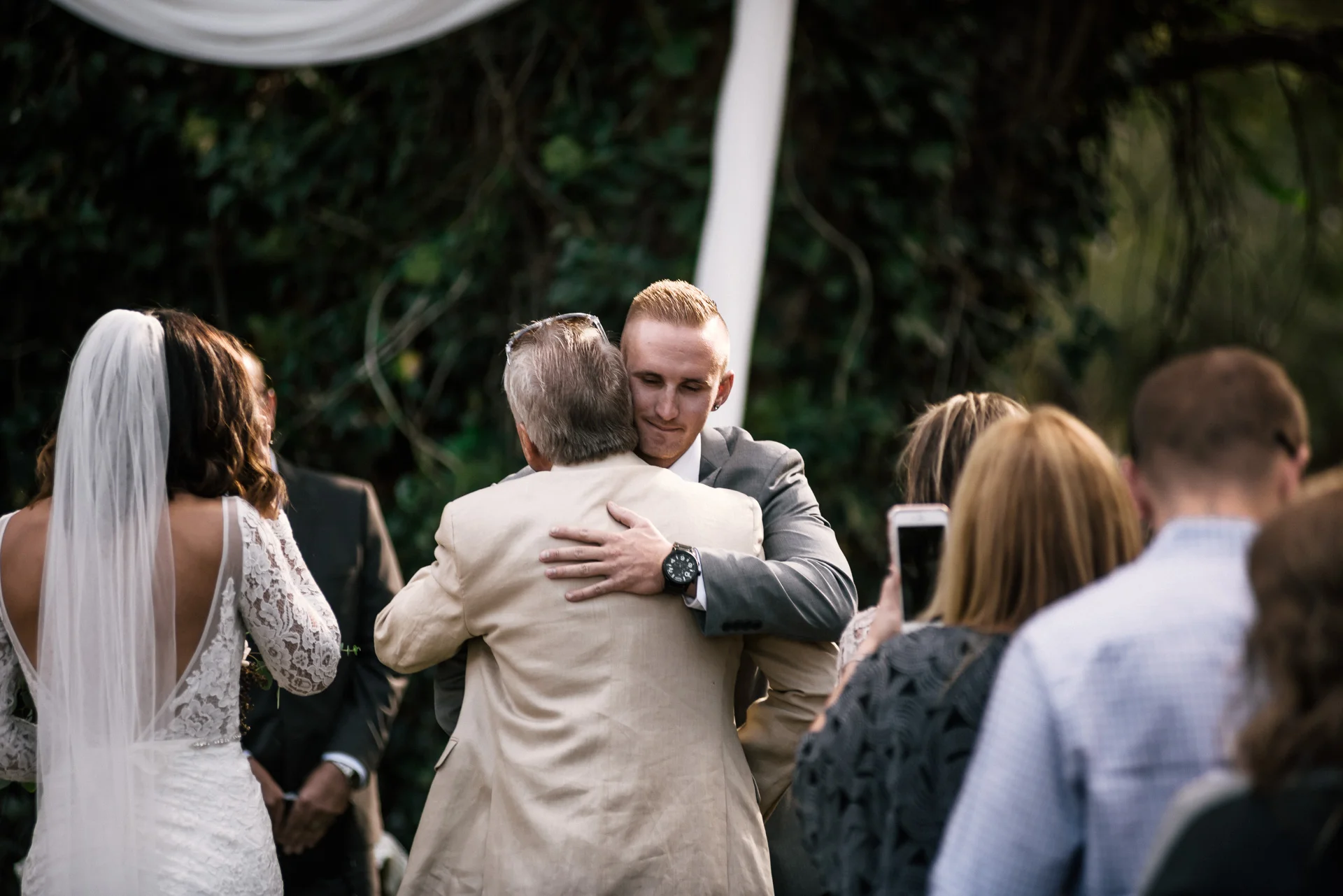 groom hugs brides father at rustic pymm ranch wedding venue in winchester california