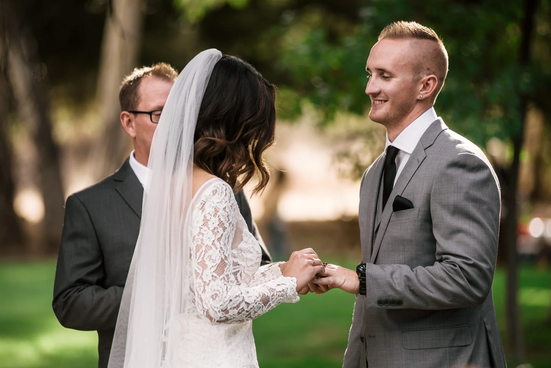bride puts ring on grooms finger during ceremony at rustic pymm ranch wedding venue in winchester california