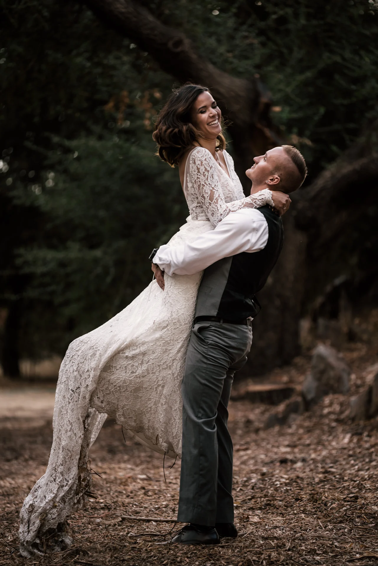 groom lifts his happy bride at rustic pymm ranch wedding venue in winchester california