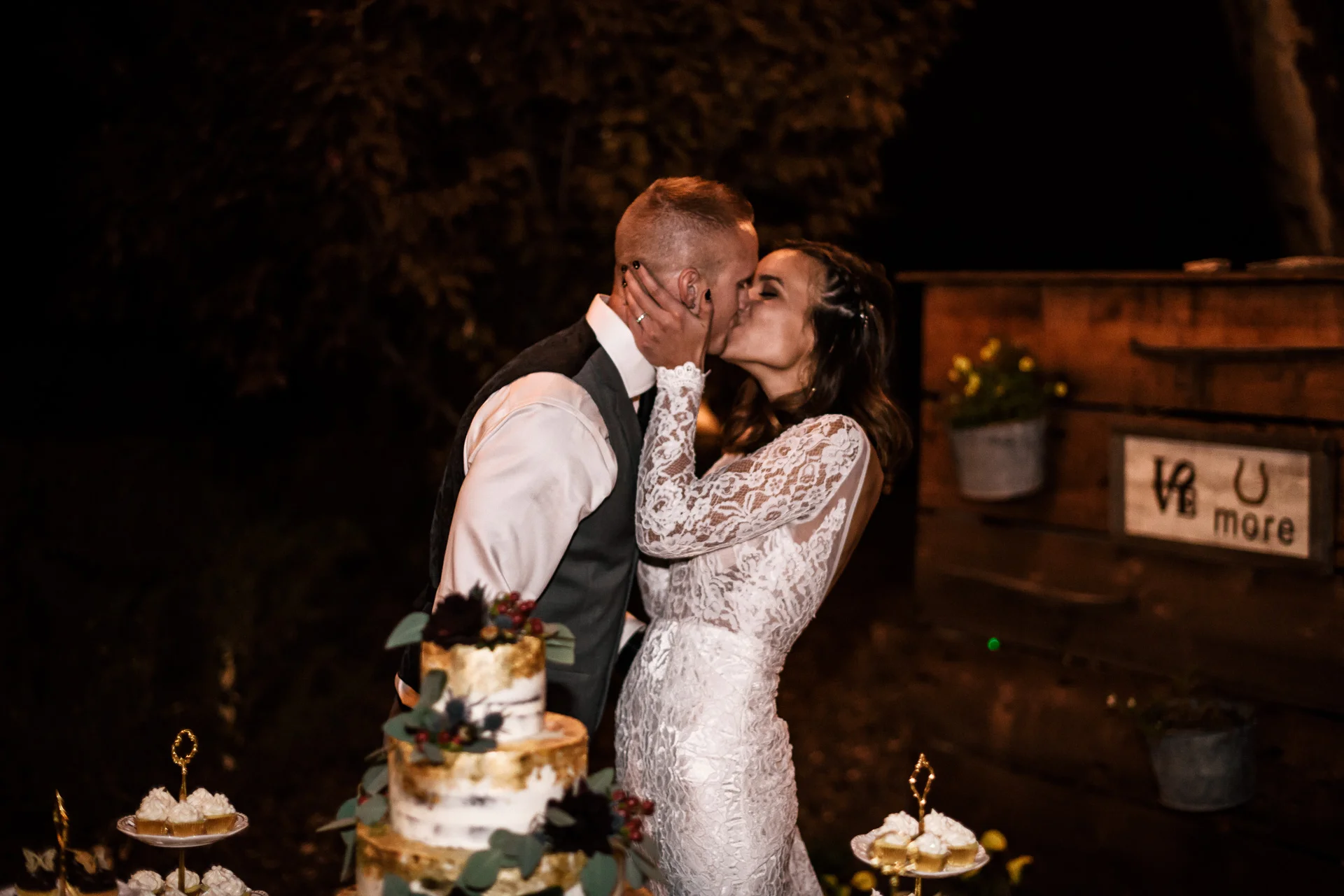 Bride and groom kiss after cake cutting at rustic pymm ranch wedding venue in winchester california