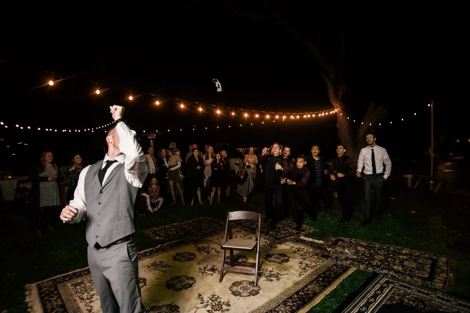 groomsmen go after garter at rustic pymm ranch wedding venue in winchester california