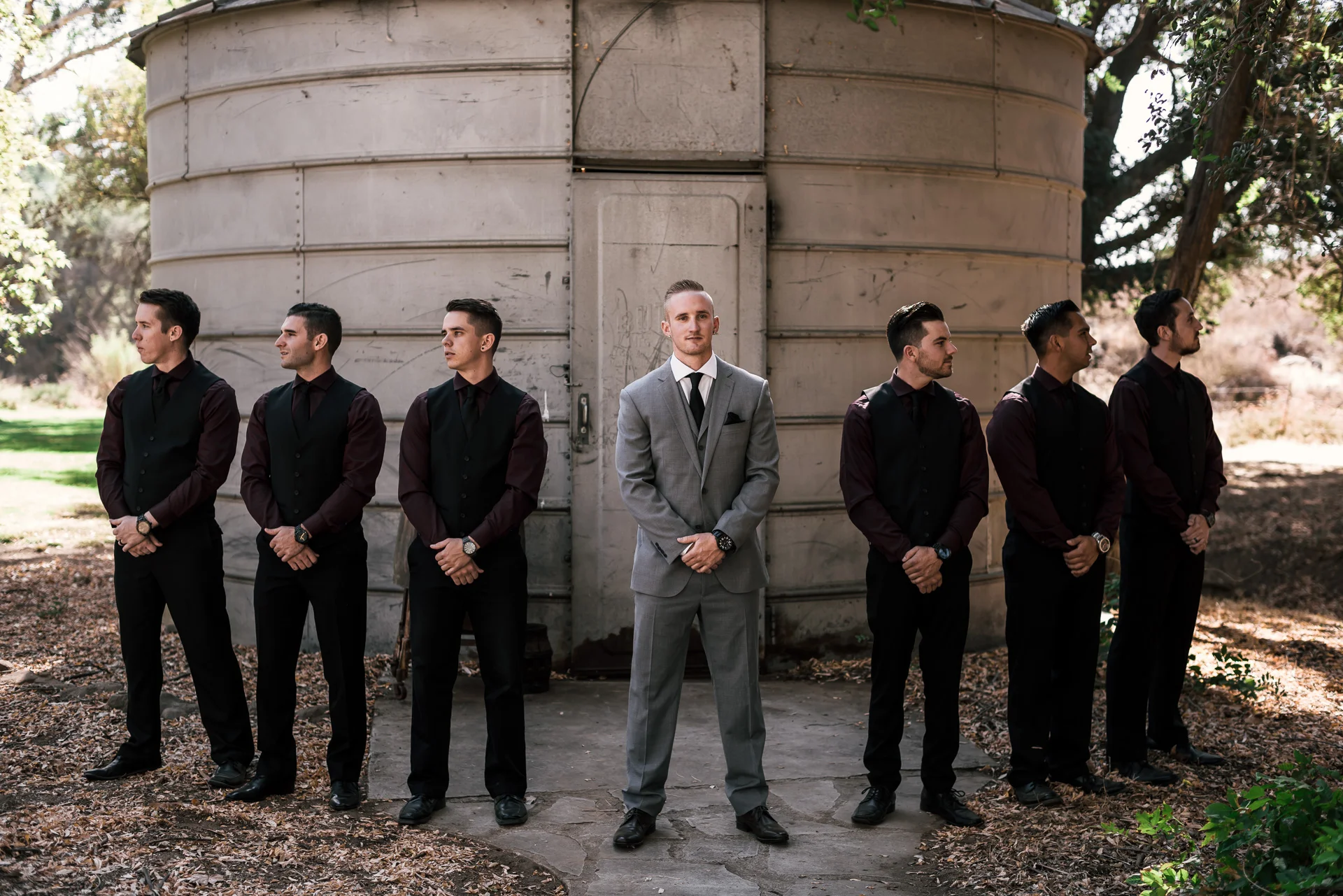 groom poses with groomsmen at rustic pymm ranch wedding venue in winchester california