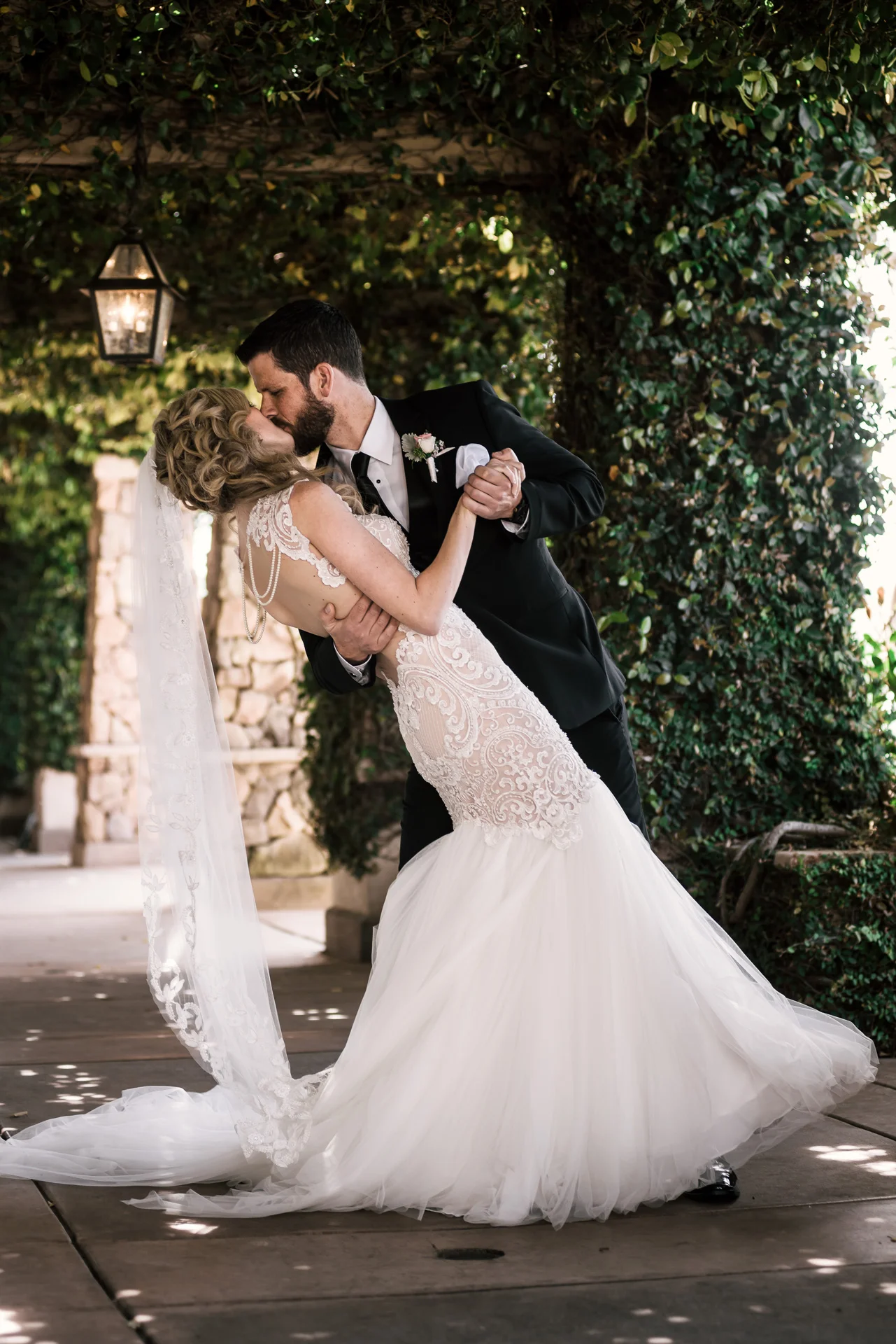 groom kiss his bride as he romanticaly dips her at the Twin Oaks Golf Course in San Marcos, San Diegos premier wedding venue
