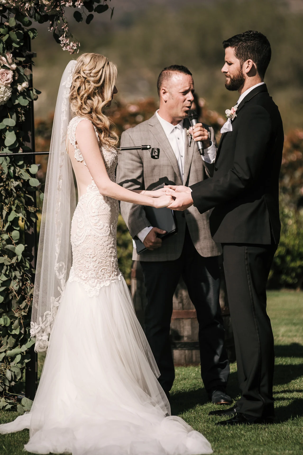 bride and groom hold hands during wedding ceremony at the Twin Oaks Golf Course in San Marcos, San Diegos premier wedding venue