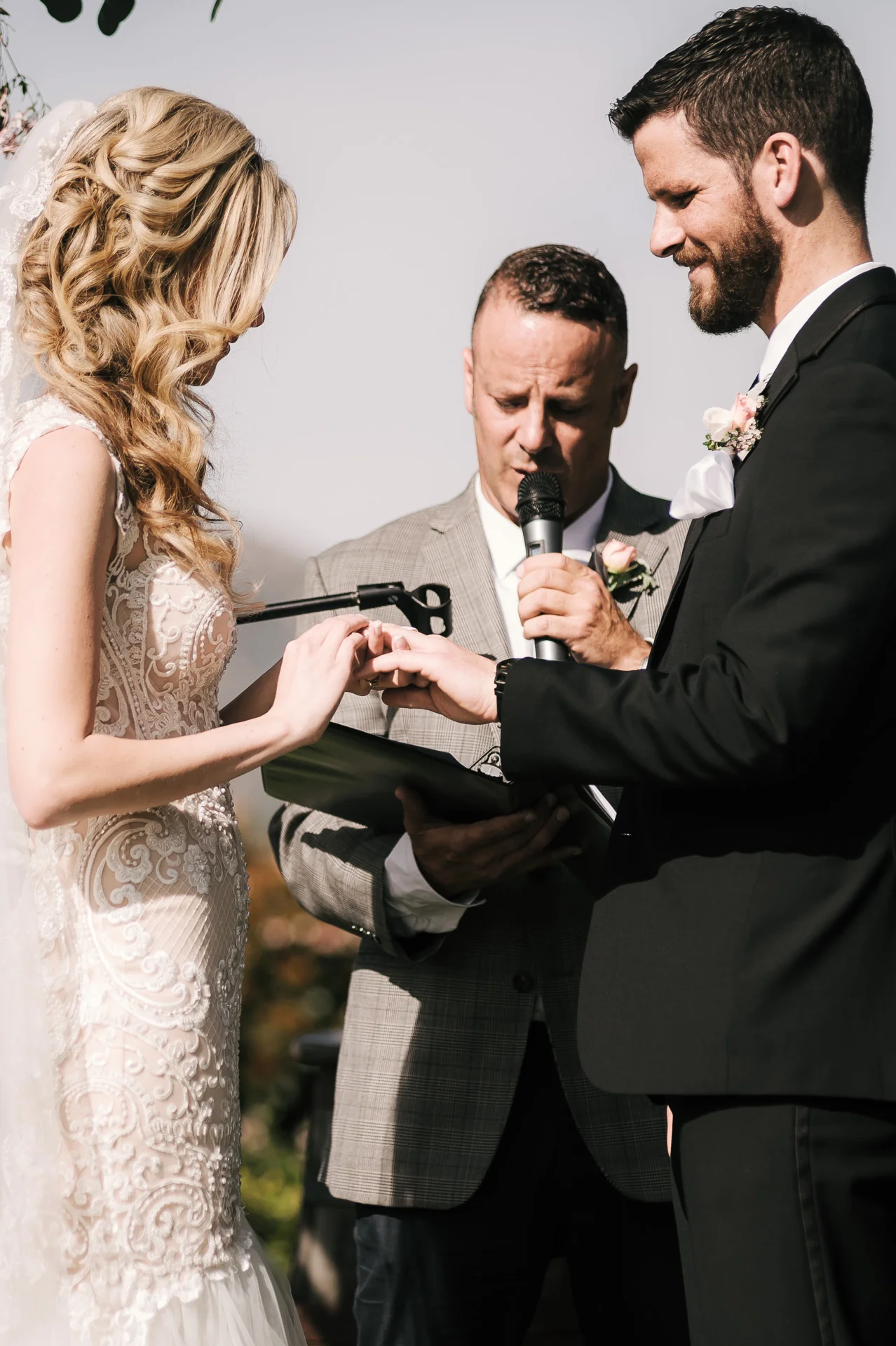 Bride palces ring on grooms finger at the Twin Oaks Golf Course in San Marcos, San Diegos premier wedding venue