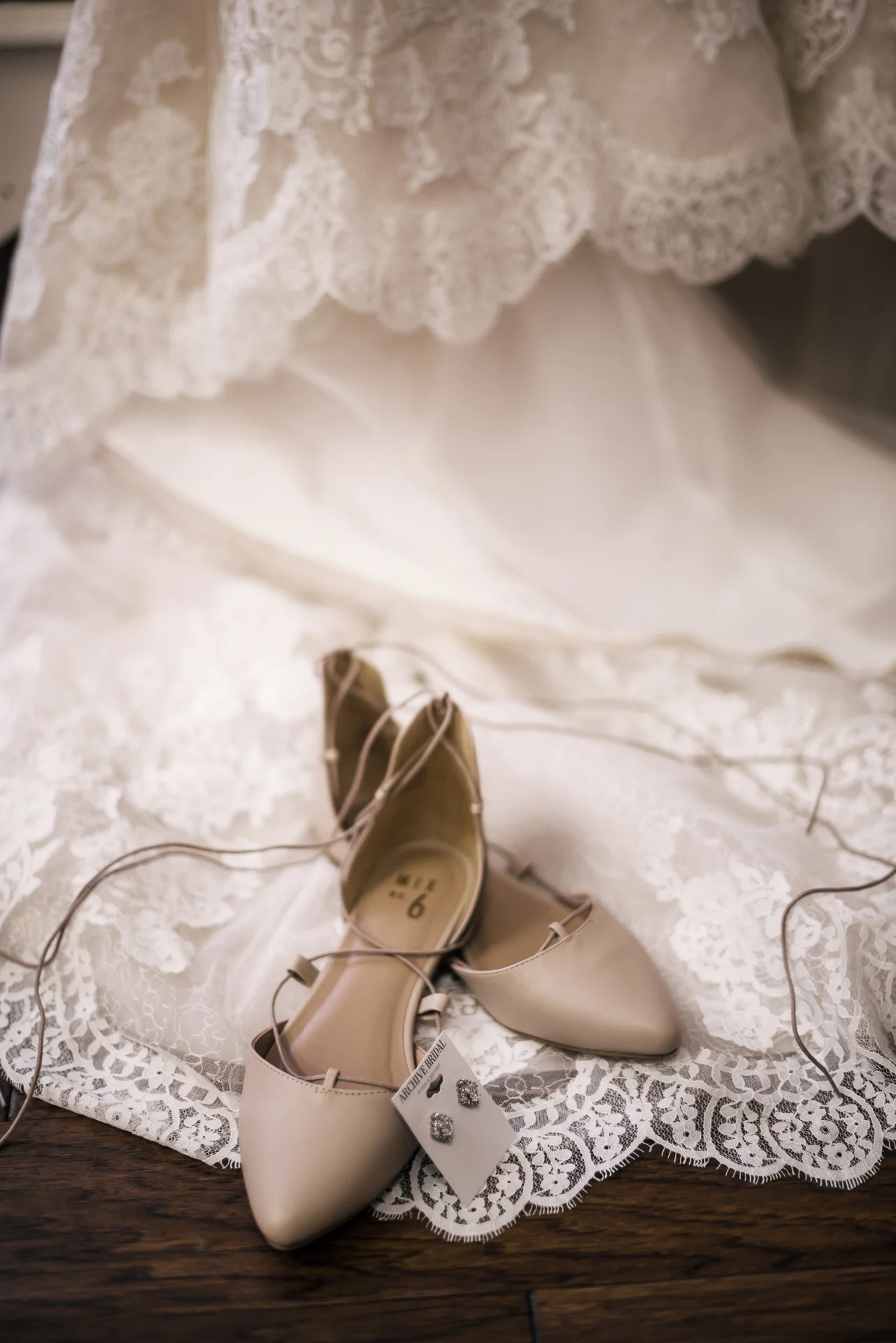 wedding shoes and jewlery displayed in front of brides dress at the secret garden located at the Historic Parish ranch in Oak Glen California