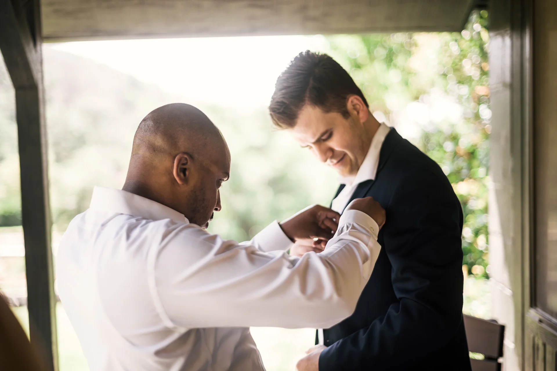 Best man fixes grooms handkerchief at the secret garden located at the Historic Parish ranch in Oak Glen California