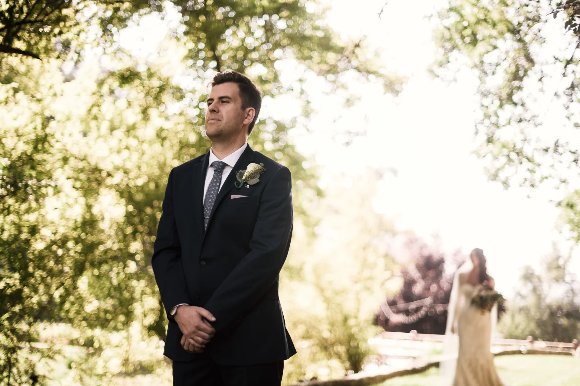 groom waits with anticipation as bride approaches for their first look at the secret garden located at the Historic Parish ranch in Oak Glen California