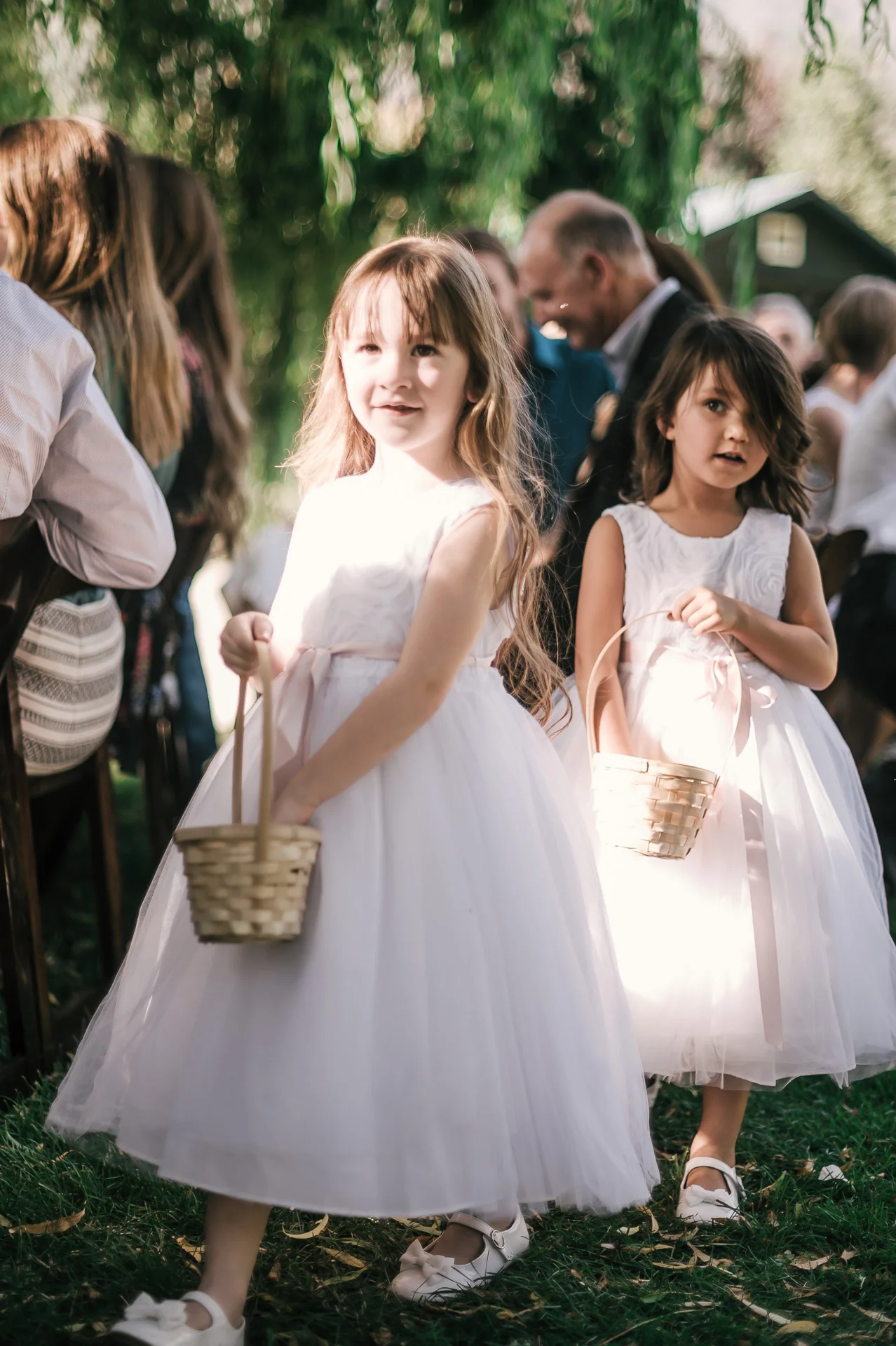 flower girls spread petals as they come down the aisle at the secret garden located at the Historic Parish ranch in Oak Glen California