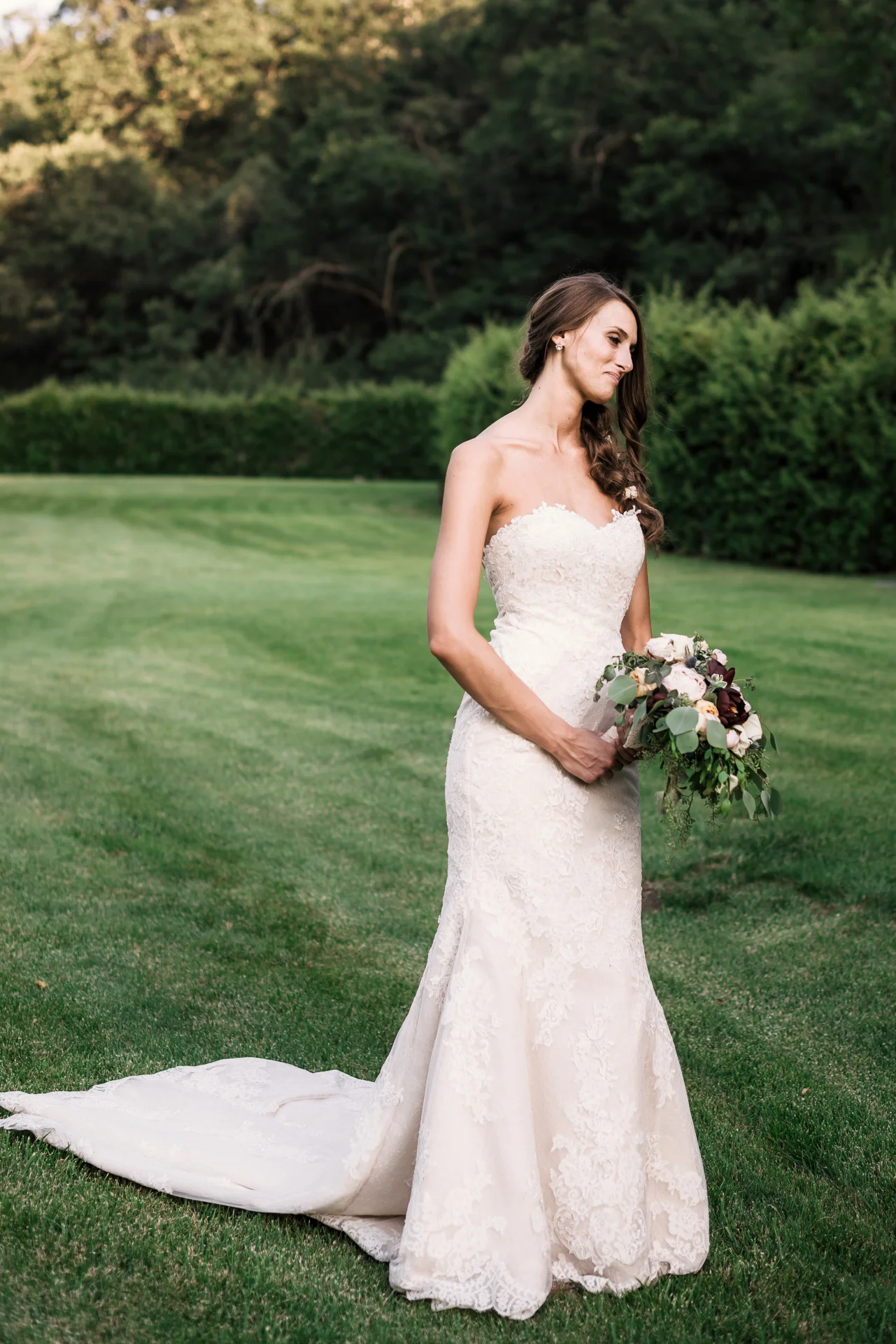 beautiful bride poses in her wedding dress at the secret garden located at the Historic Parish ranch in Oak Glen California
