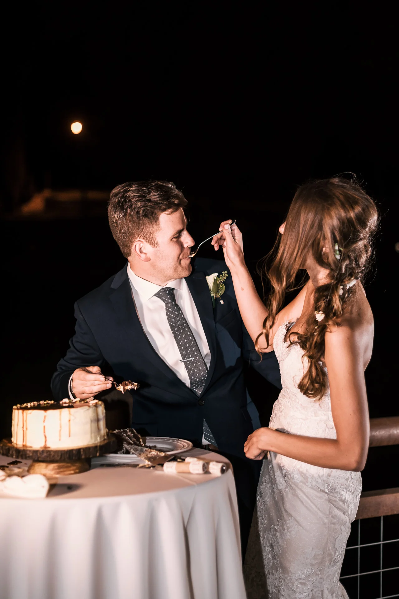 bride feeds groom a piece of cake at the secret garden located at the Historic Parish ranch in Oak Glen California